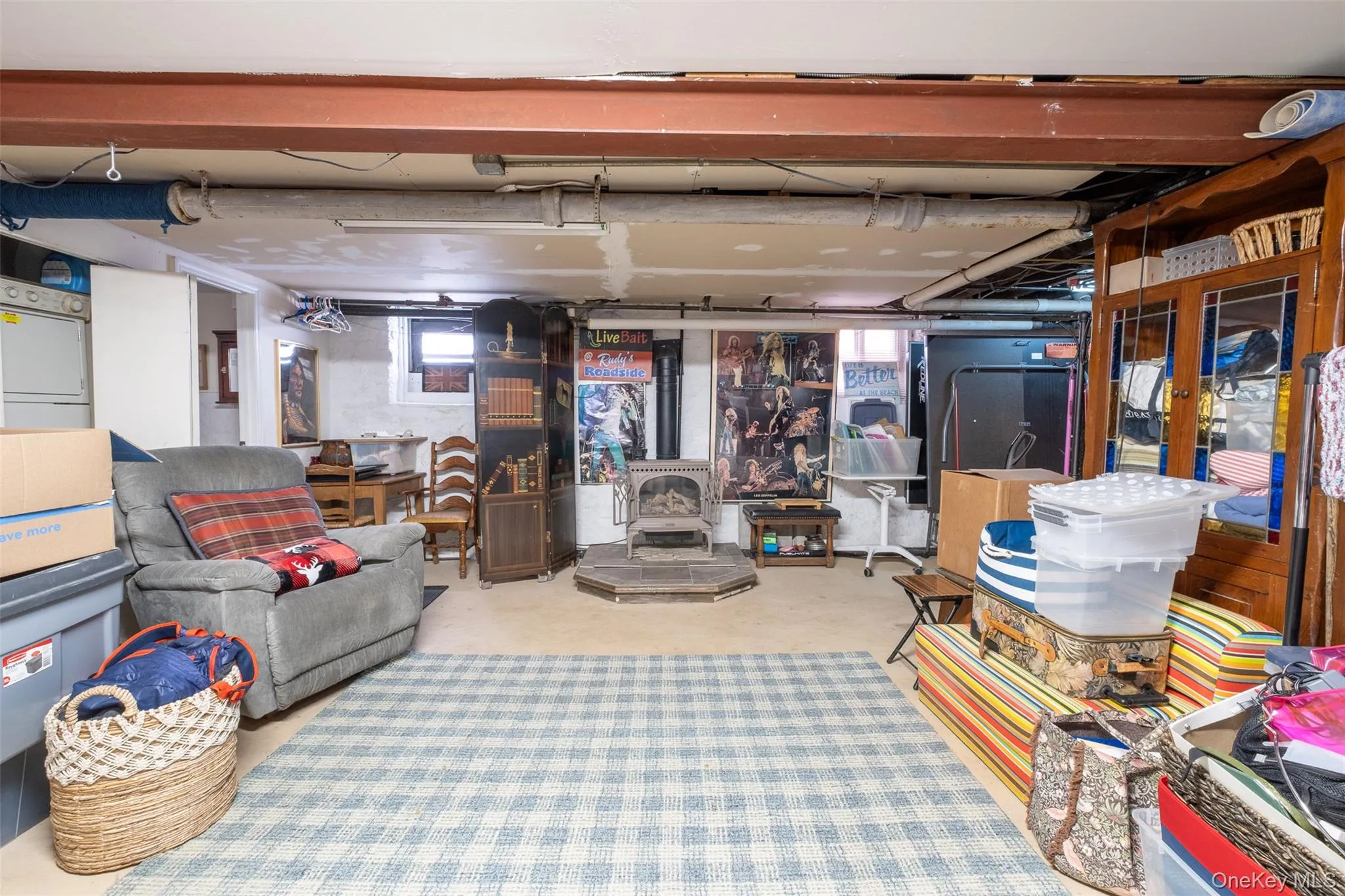 Basement with a wood stove and white refrigerator Basement with a wood stove and white refrigerator