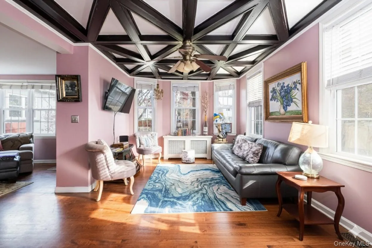 Living area with coffered ceiling, radiator heating unit, hardwood / wood-style flooring, and beamed ceiling Living area with coffered ceiling, radiator heating unit, hardwood / wood-style flooring, and beamed ceiling