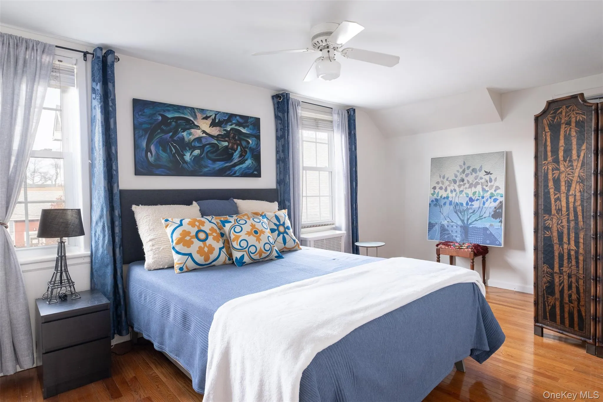 Bedroom featuring wood finished floors, ceiling fan, and vaulted ceiling Bedroom featuring wood finished floors, ceiling fan, and vaulted ceiling