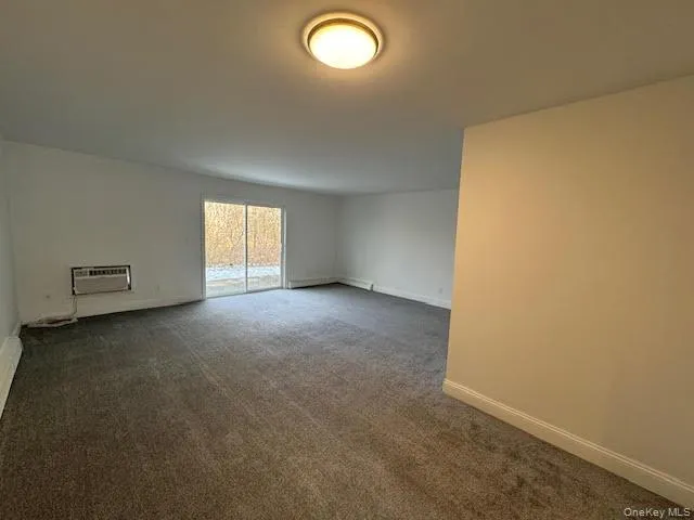 Dining and living room with sliding door opening to a back concrete patio Dining and living room with sliding door opening to a back concrete patio