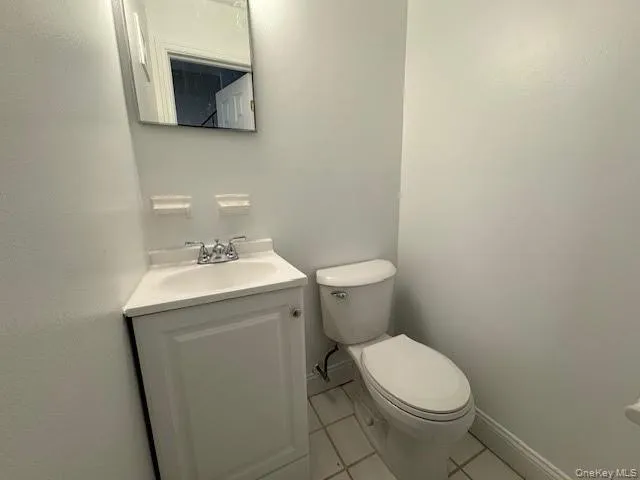 Half bath with vanity and ceramic tile patterned floors Half bath with vanity and ceramic tile patterned floors