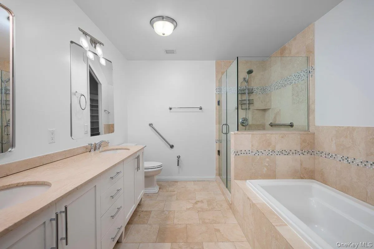 Full bathroom featuring double vanity, a stall shower, and a bath Full bathroom featuring double vanity, a stall shower, and a bath
