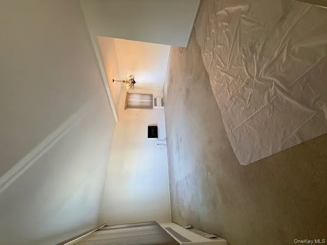 Unfurnished living room featuring carpet floors and a chandelier Unfurnished living room featuring carpet floors and a chandelier