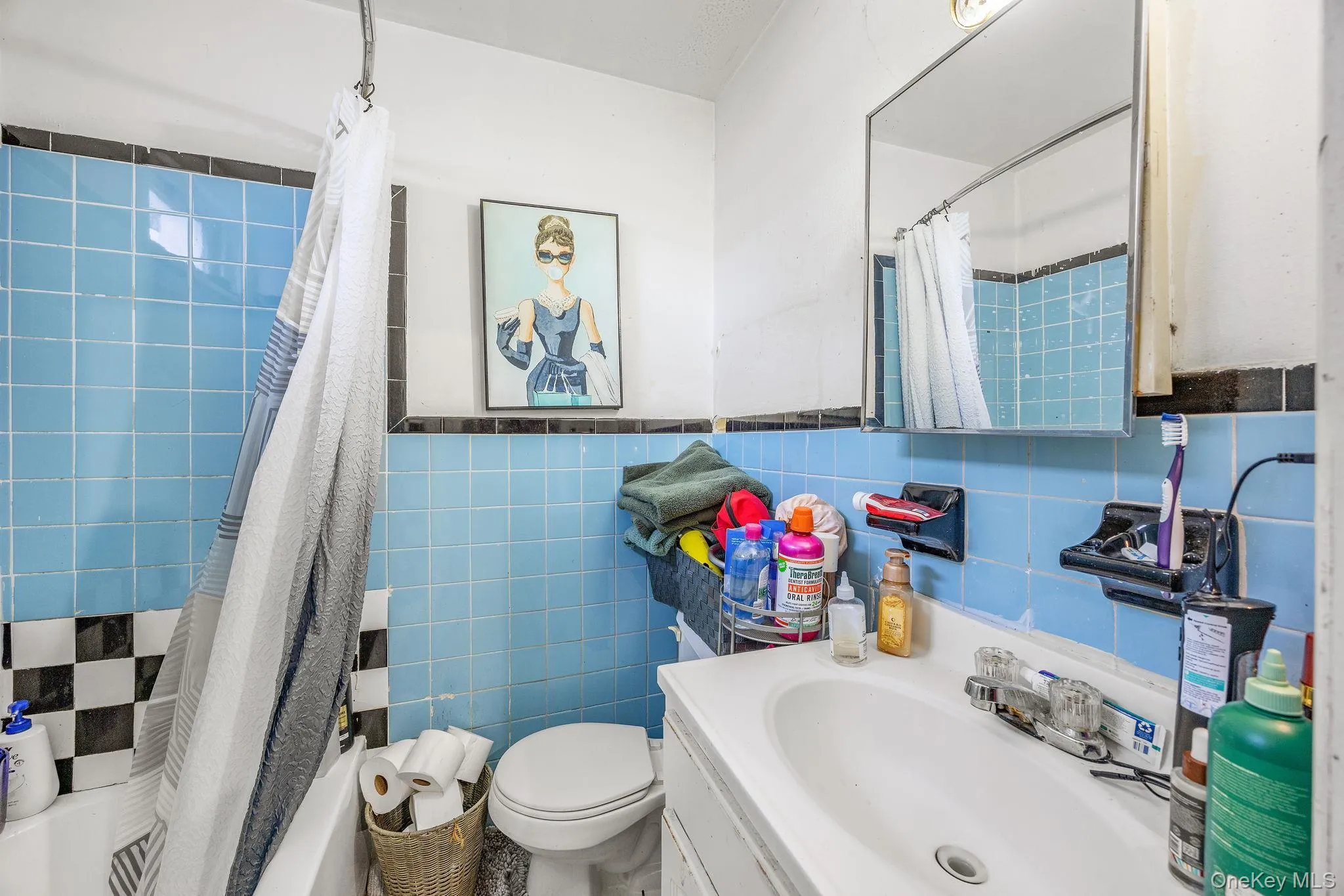 Bathroom featuring vanity, tile walls, a wainscoted wall, and shower / tub combo with curtain Bathroom featuring vanity, tile walls, a wainscoted wall, and shower / tub combo with curtain