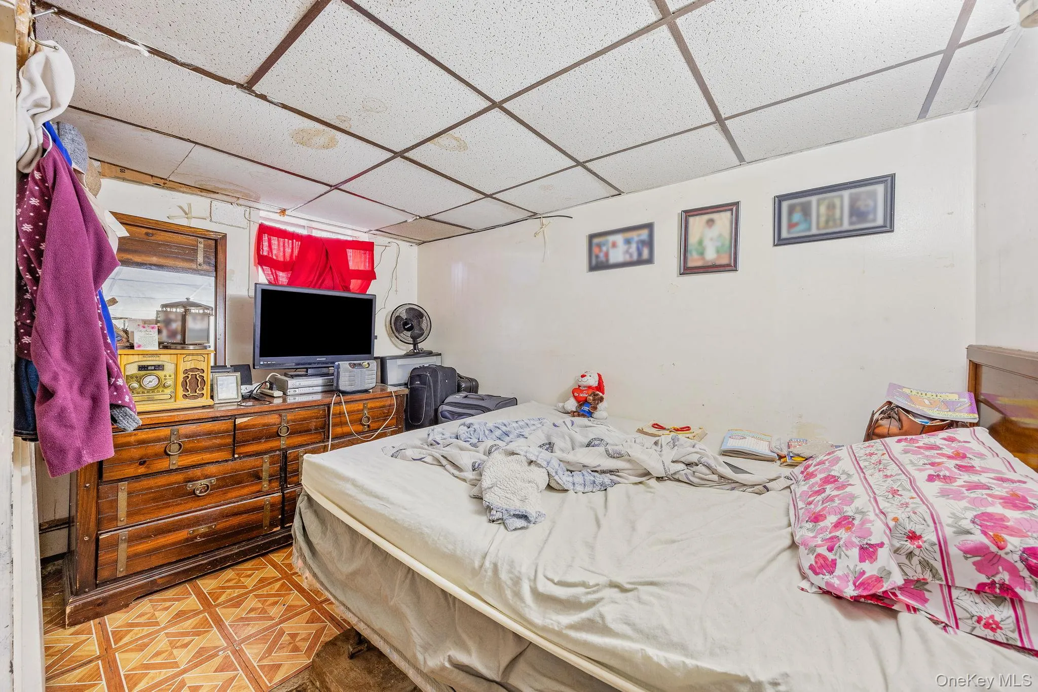 Bedroom featuring a drop ceiling and a baseboard radiator Bedroom featuring a drop ceiling and a baseboard radiator