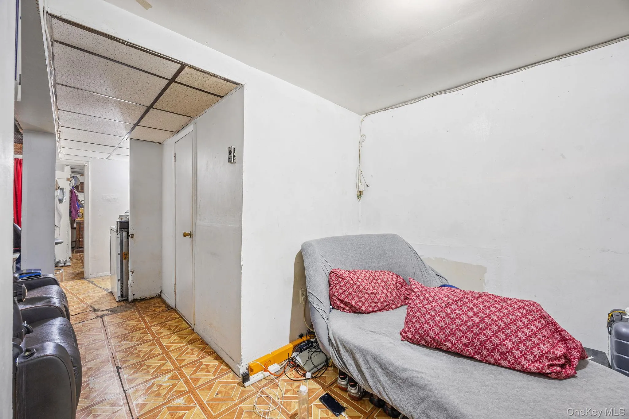 Bedroom featuring light flooring, a closet, and a paneled ceiling Bedroom featuring light flooring, a closet, and a paneled ceiling
