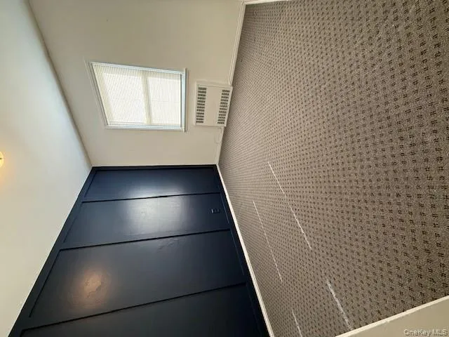 Unfurnished bedroom with carpet and radiator heating unit Unfurnished bedroom with carpet and radiator heating unit