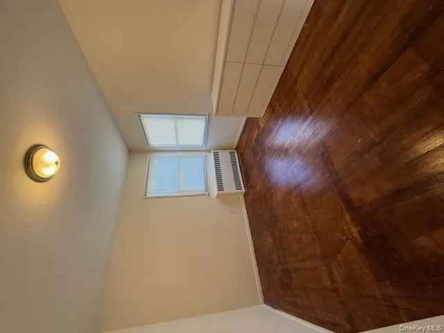 Unfurnished room with radiator heating unit and dark wood-type flooring Unfurnished room with radiator heating unit and dark wood-type flooring