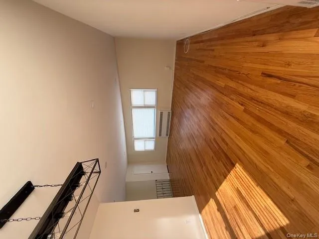 Unfurnished living room featuring light wood-style flooring and radiator heating unit Unfurnished living room featuring light wood-style flooring and radiator heating unit