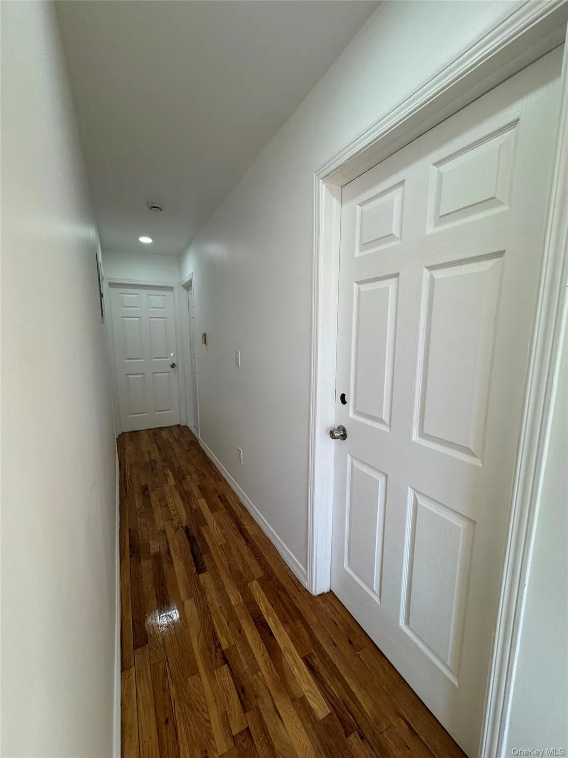 Hallway featuring dark wood-style flooring and recessed lighting Hallway featuring dark wood-style flooring and recessed lighting