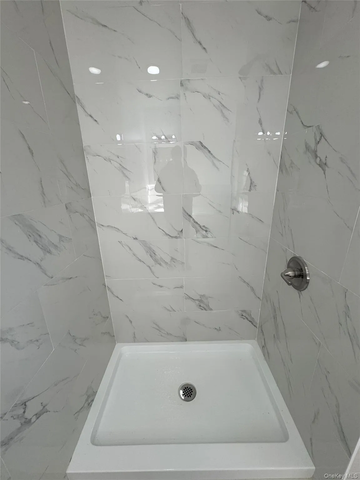 Bathroom featuring a marble finish shower Bathroom featuring a marble finish shower