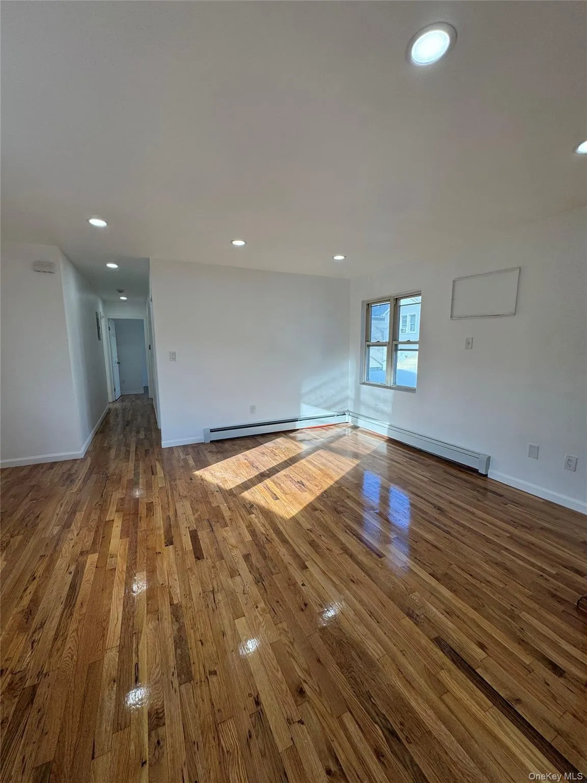 Spare room with hardwood / wood-style floors, recessed lighting, and a baseboard heating unit Spare room with hardwood / wood-style floors, recessed lighting, and a baseboard heating unit