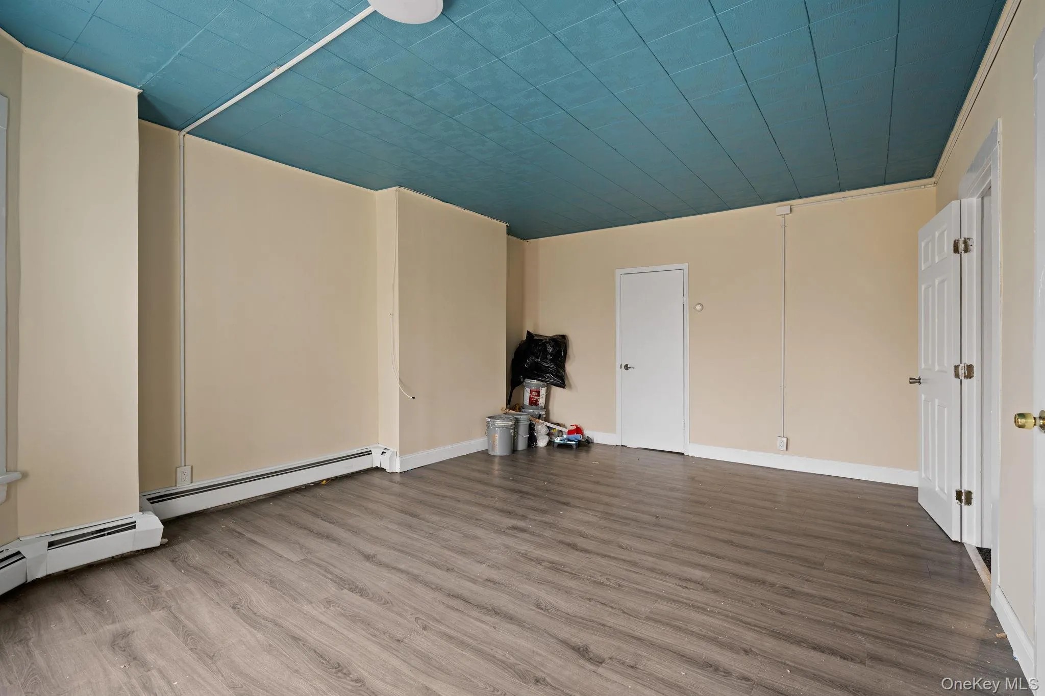 Spare room with wood finished floors and a baseboard heating unit Spare room with wood finished floors and a baseboard heating unit