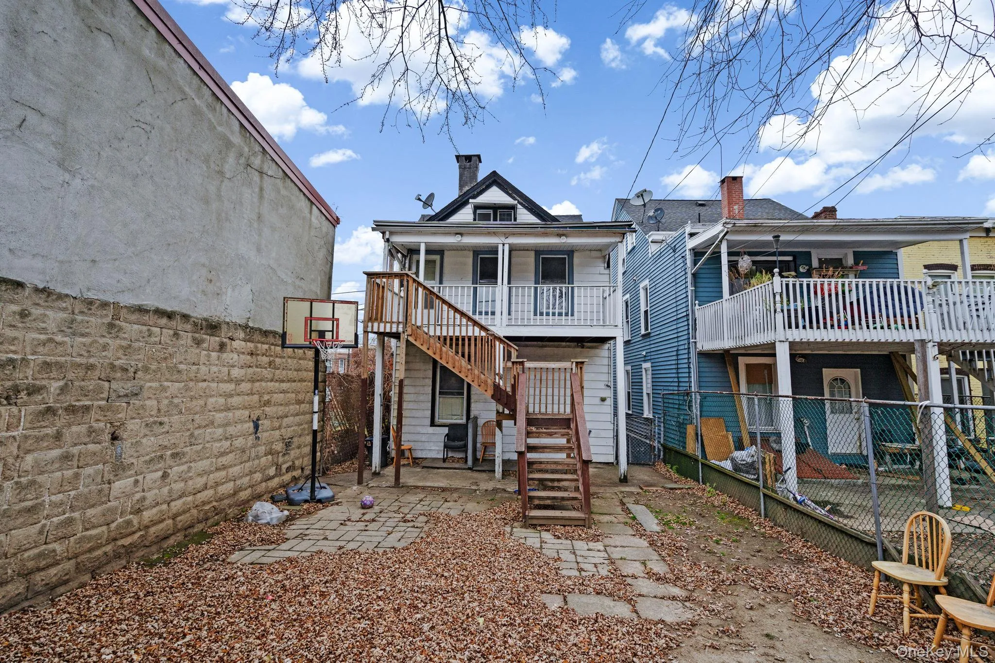 Rear view of house featuring a fenced backyard, stairway, a patio area, a chimney, and a deck Rear view of house featuring a fenced backyard, stairway, a patio area, a chimney, and a deck