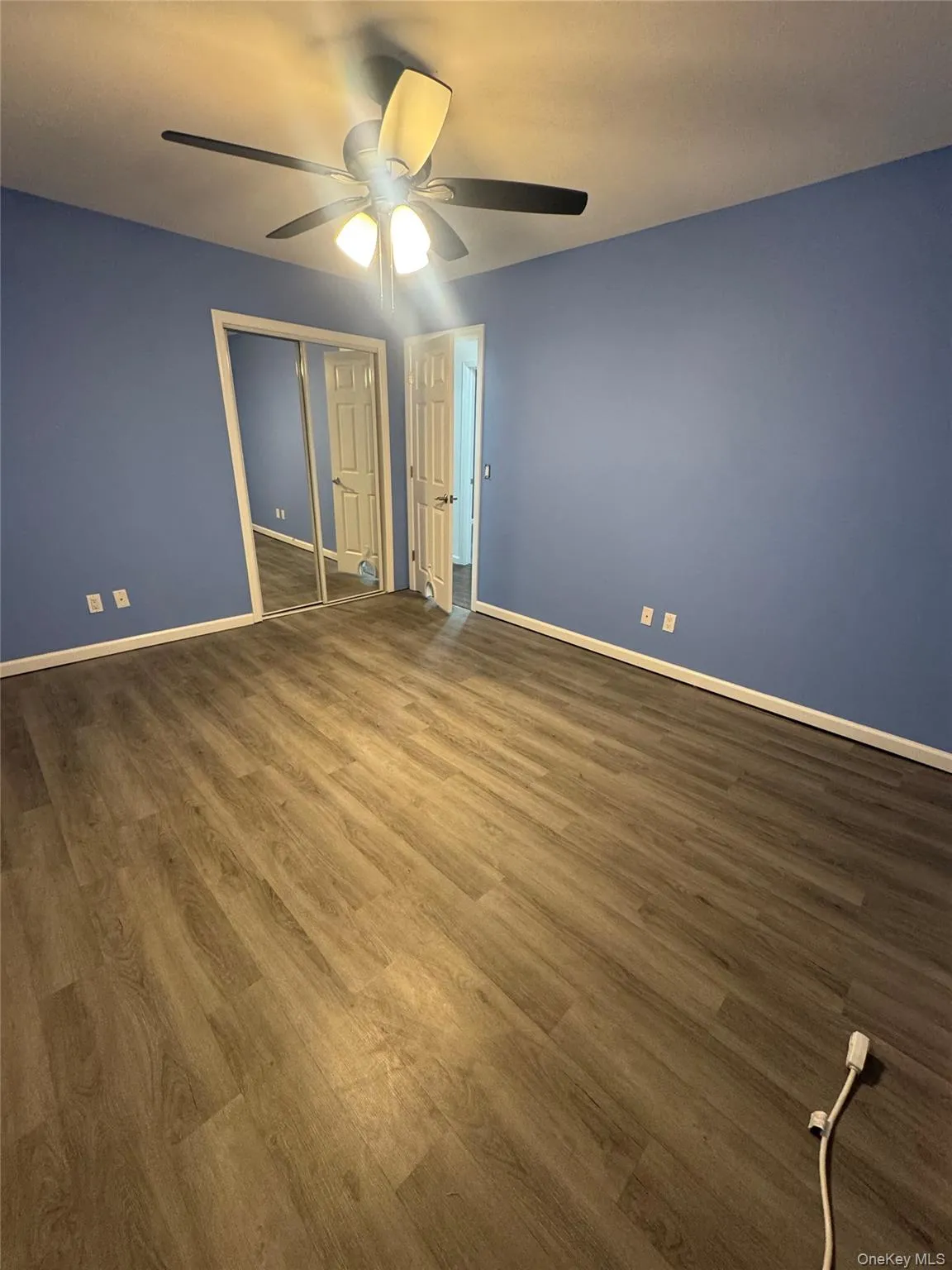 Unfurnished bedroom with wood finished floors, ceiling fan, and a closet Unfurnished bedroom with wood finished floors, ceiling fan, and a closet