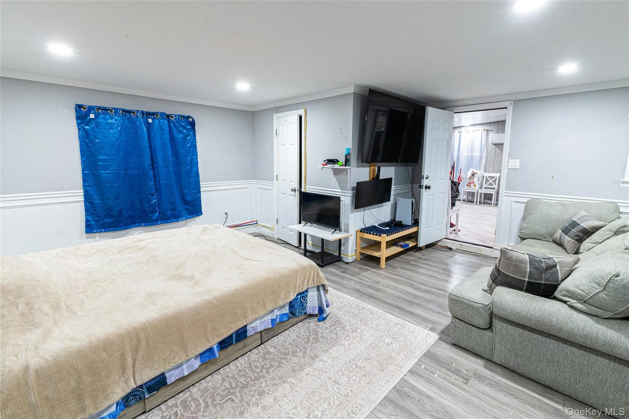 Bedroom with crown molding, wood finished floors, wainscoting, and recessed lighting Bedroom with crown molding, wood finished floors, wainscoting, and recessed lighting