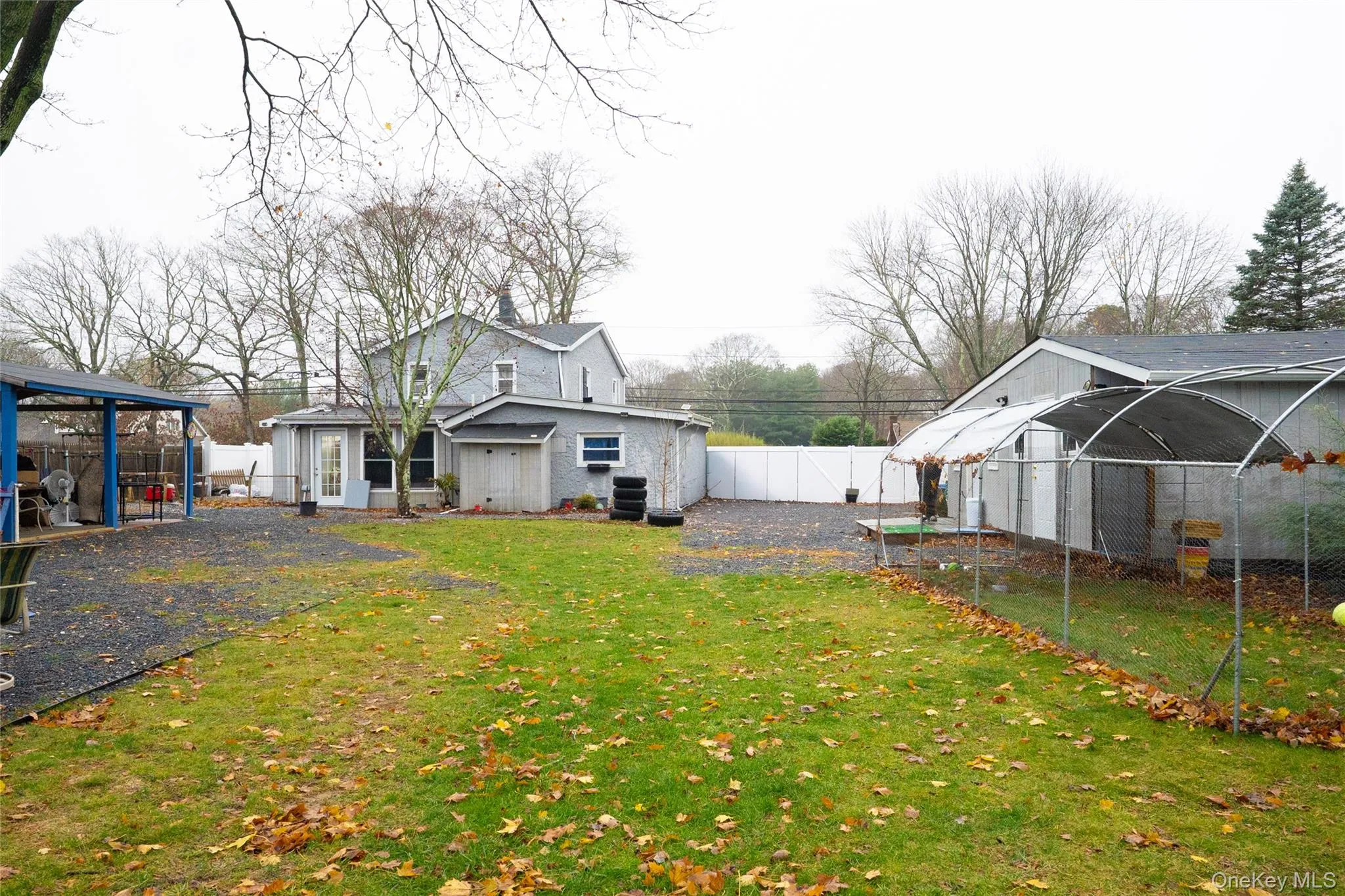 Rear view of house with a fenced backyard and an outbuilding Rear view of house with a fenced backyard and an outbuilding