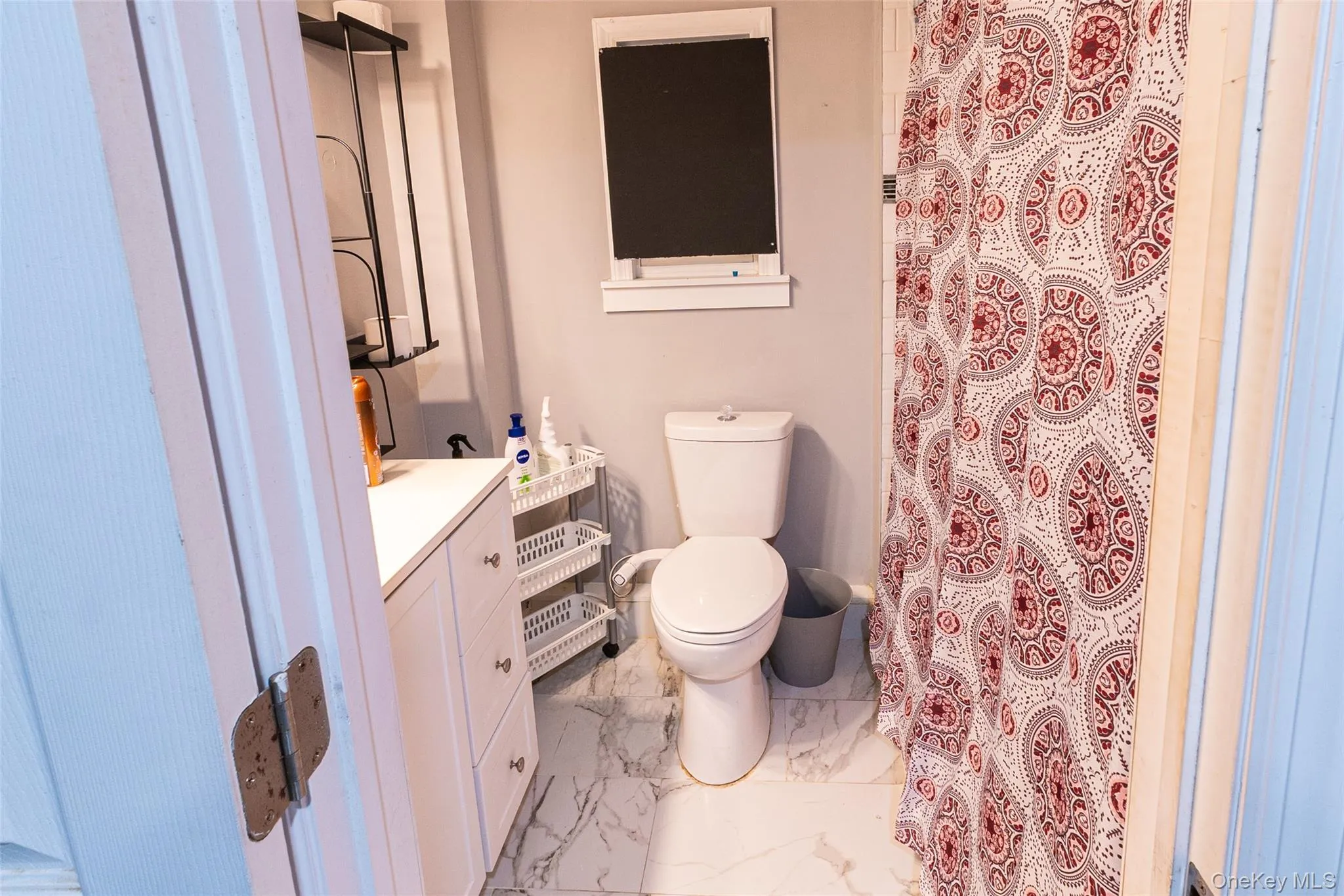 Bathroom featuring vanity, a shower with curtain, and light marble finish flooring Bathroom featuring vanity, a shower with curtain, and light marble finish flooring