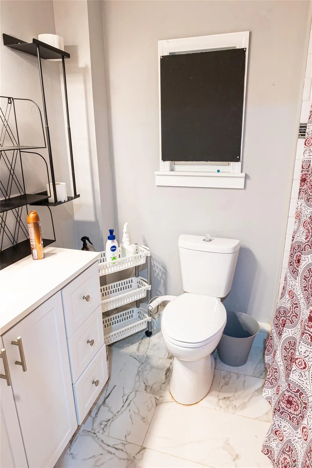 Bathroom featuring light marble finish flooring, vanity, and curtained shower Bathroom featuring light marble finish flooring, vanity, and curtained shower