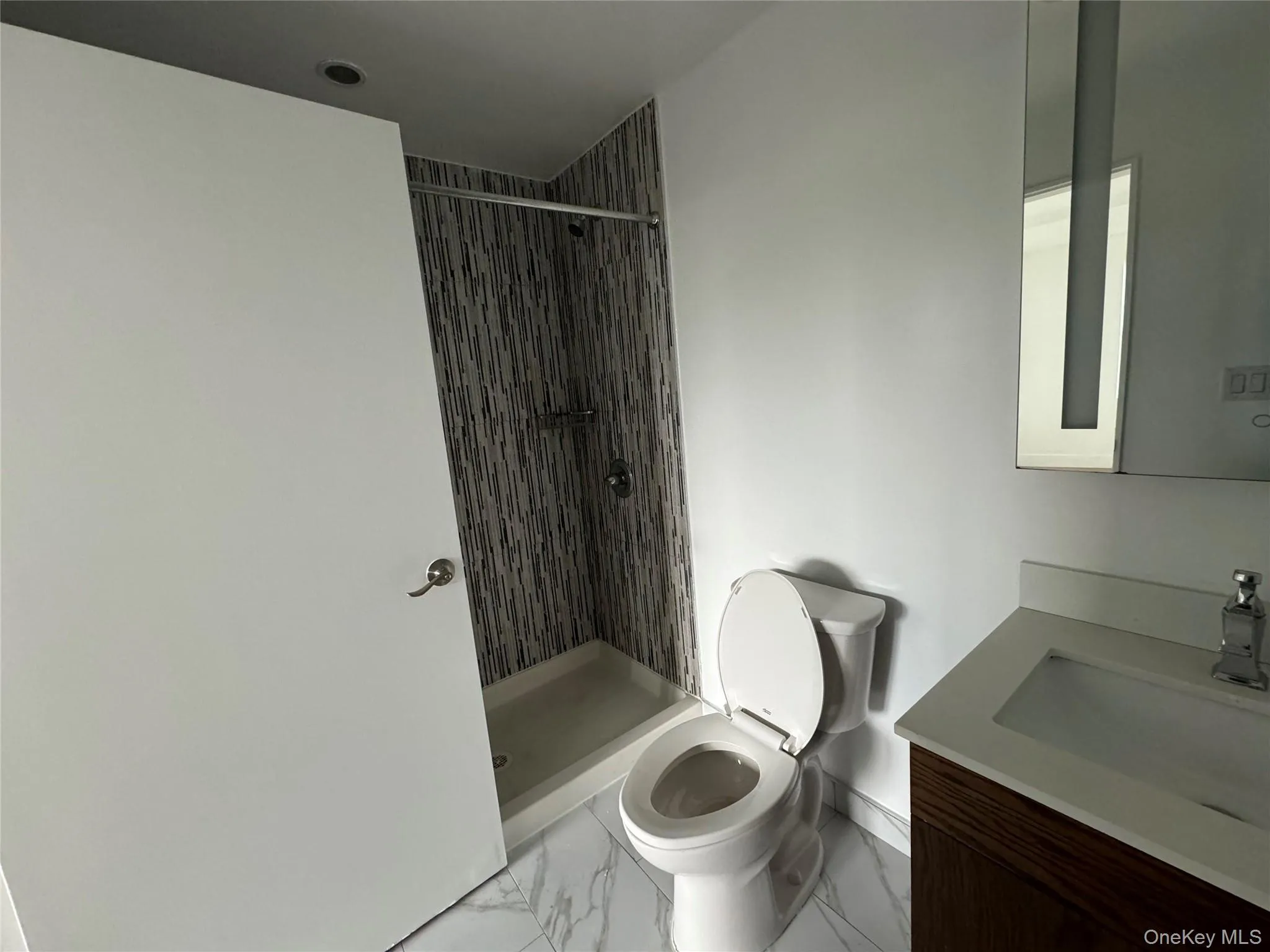 Full bathroom featuring vanity, marble finish flooring, and a shower stall Full bathroom featuring vanity, marble finish flooring, and a shower stall