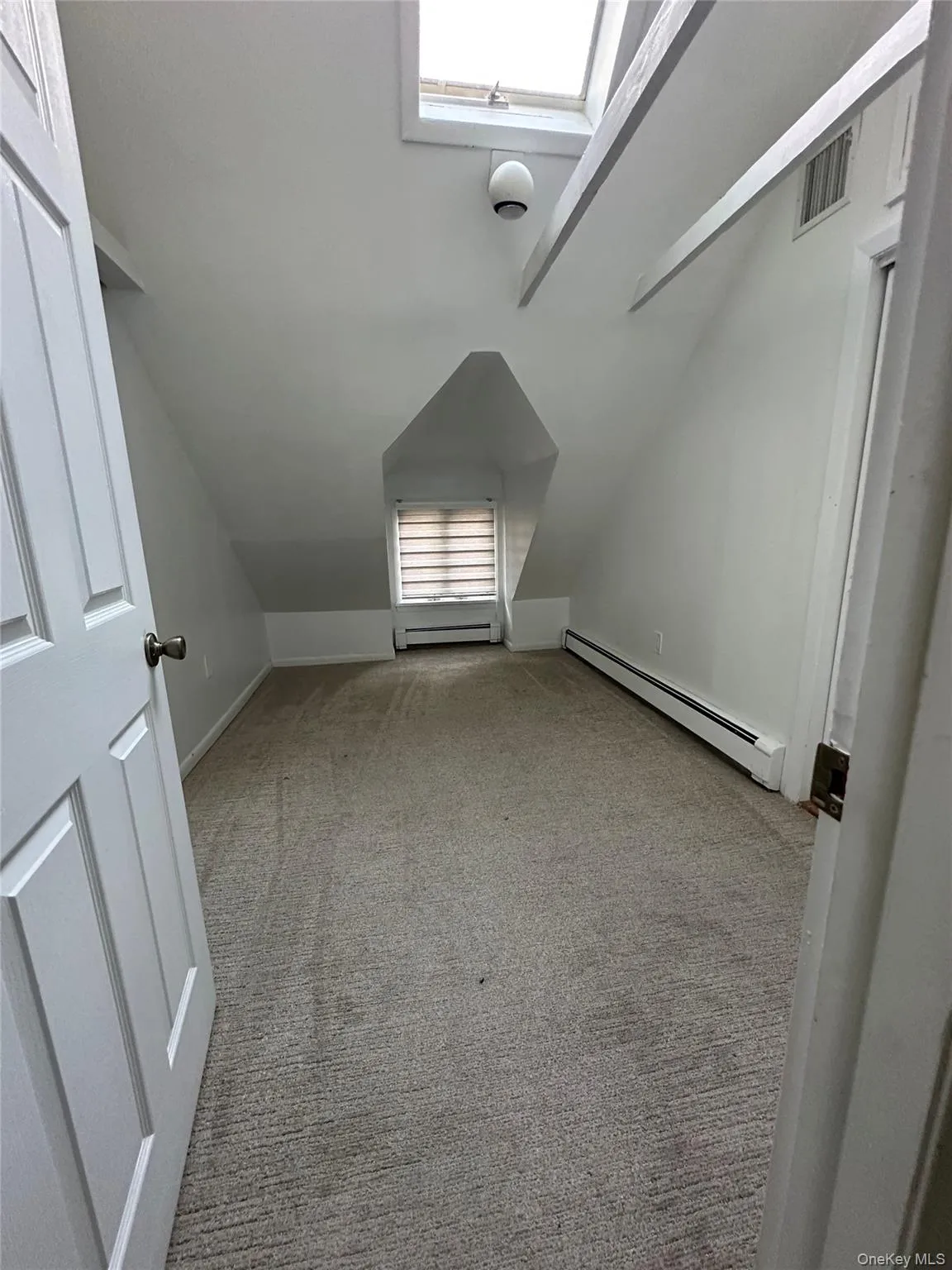 Additional living space with light carpet, a baseboard radiator, and lofted ceiling Additional living space with light carpet, a baseboard radiator, and lofted ceiling