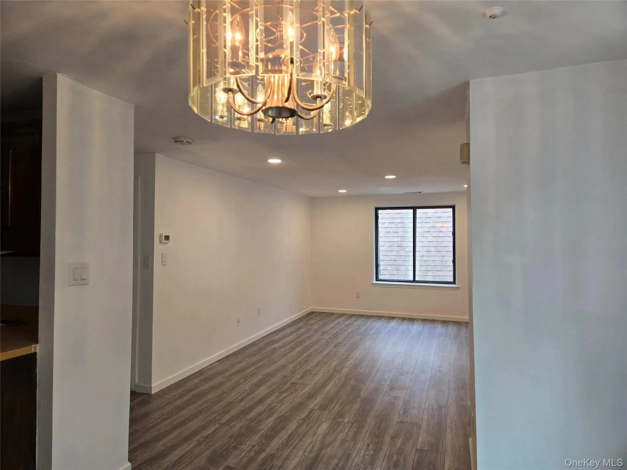 Unfurnished dining area with dark wood finished floors, a chandelier, and recessed lighting Unfurnished dining area with dark wood finished floors, a chandelier, and recessed lighting