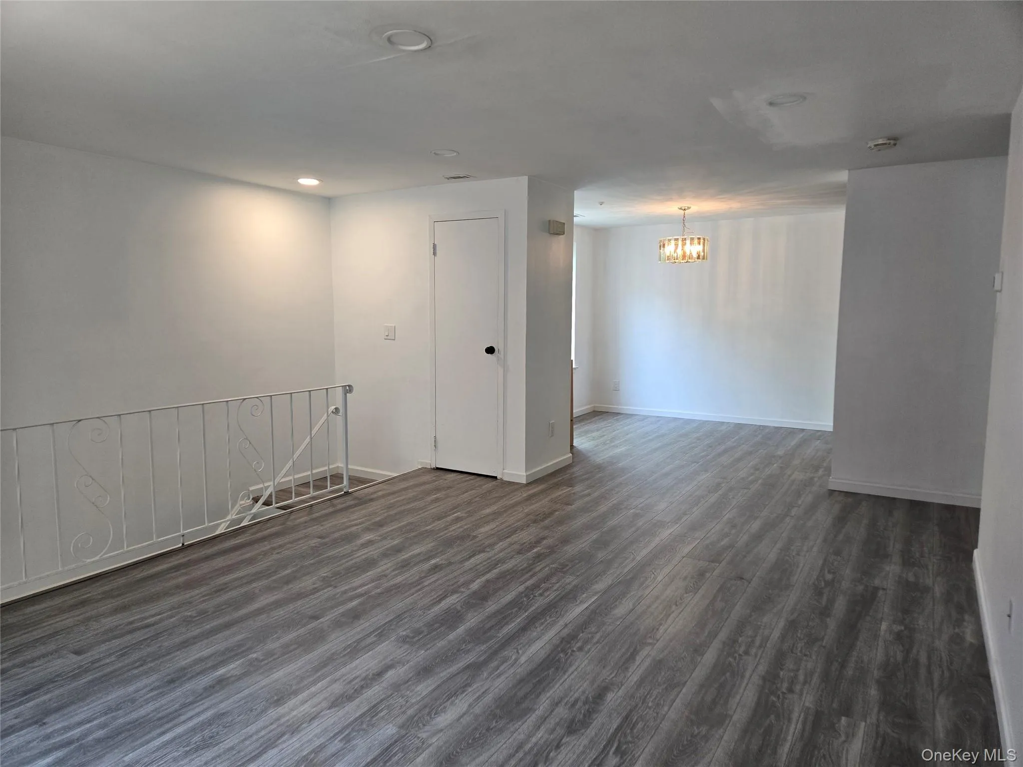 Spare room featuring recessed lighting, dark wood-style flooring, and a chandelier Spare room featuring recessed lighting, dark wood-style flooring, and a chandelier