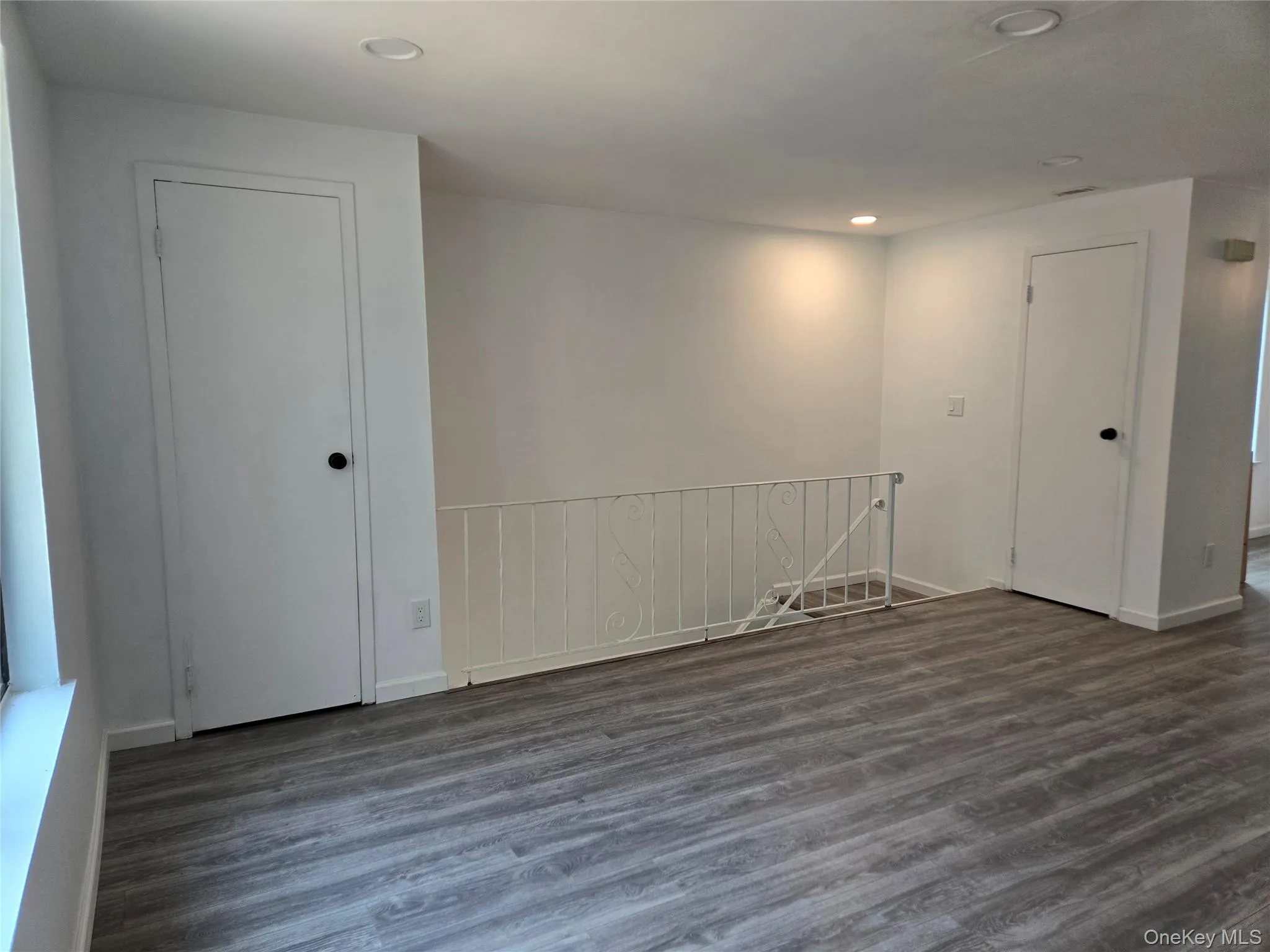 Empty room with dark wood-style floors and recessed lighting Empty room with dark wood-style floors and recessed lighting