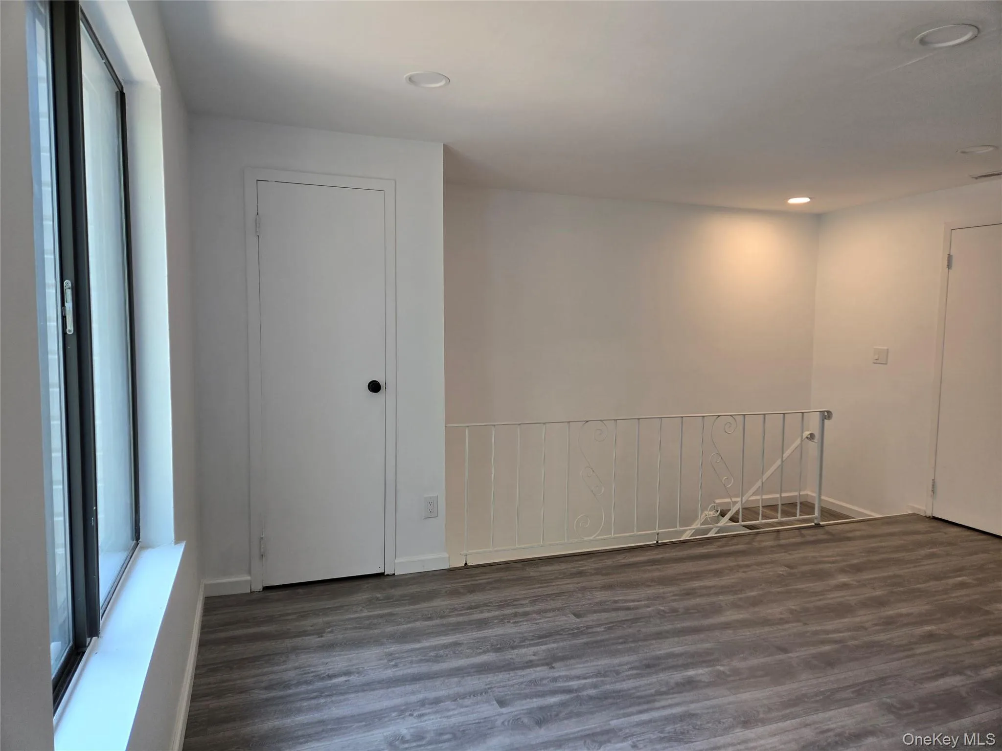 Unfurnished room featuring dark wood finished floors, recessed lighting, and plenty of natural light Unfurnished room featuring dark wood finished floors, recessed lighting, and plenty of natural light