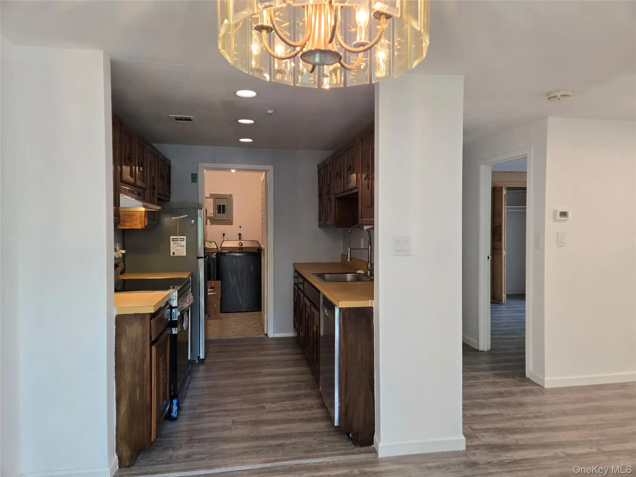 Kitchen featuring dark brown cabinets, light countertops, stainless steel appliances, dark wood-style floors, and recessed lighting Kitchen featuring dark brown cabinets, light countertops, stainless steel appliances, dark wood-style floors, and recessed lighting