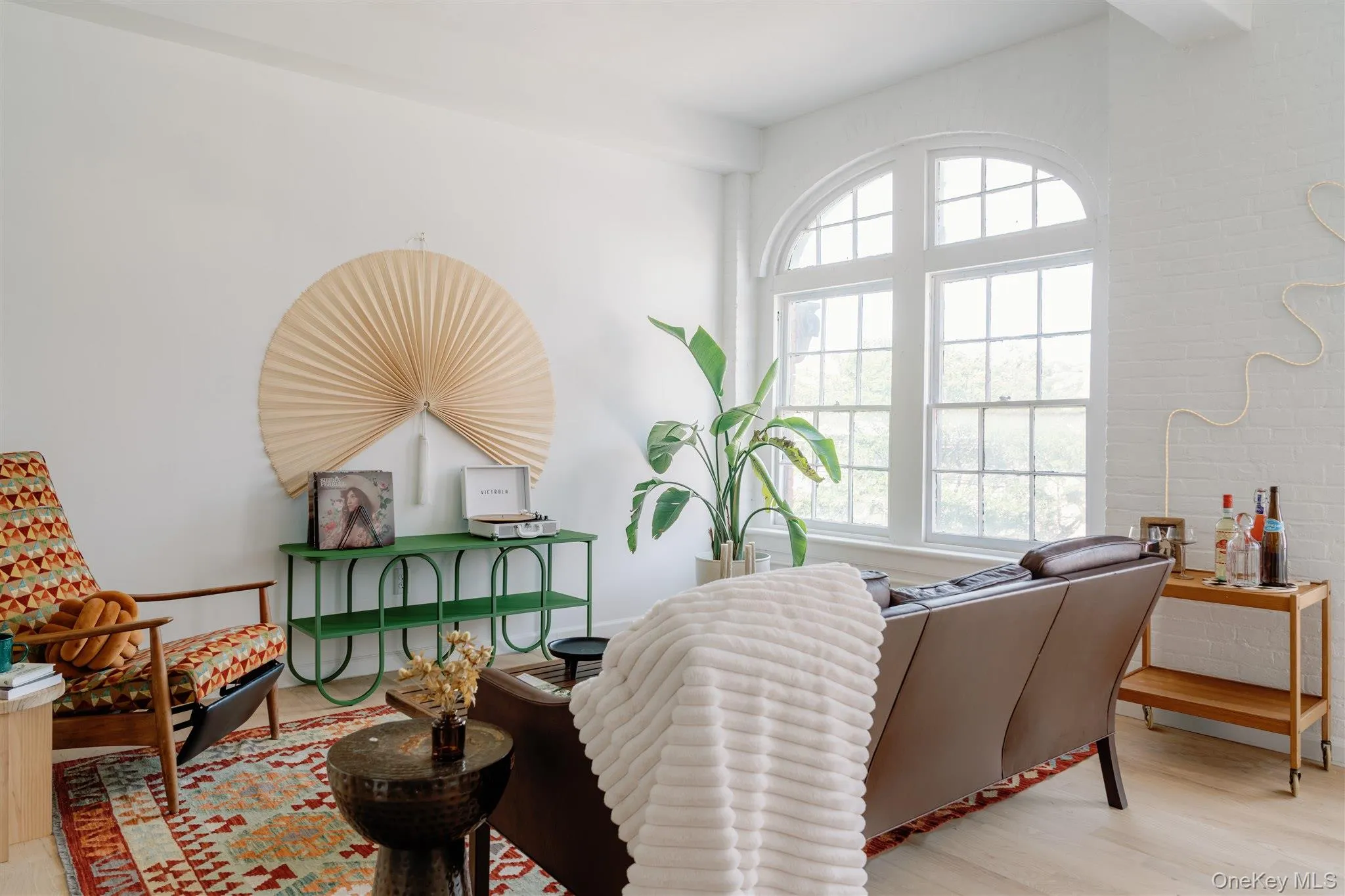 Living area featuring light wood-style flooring and brick wall Living area featuring light wood-style flooring and brick wall
