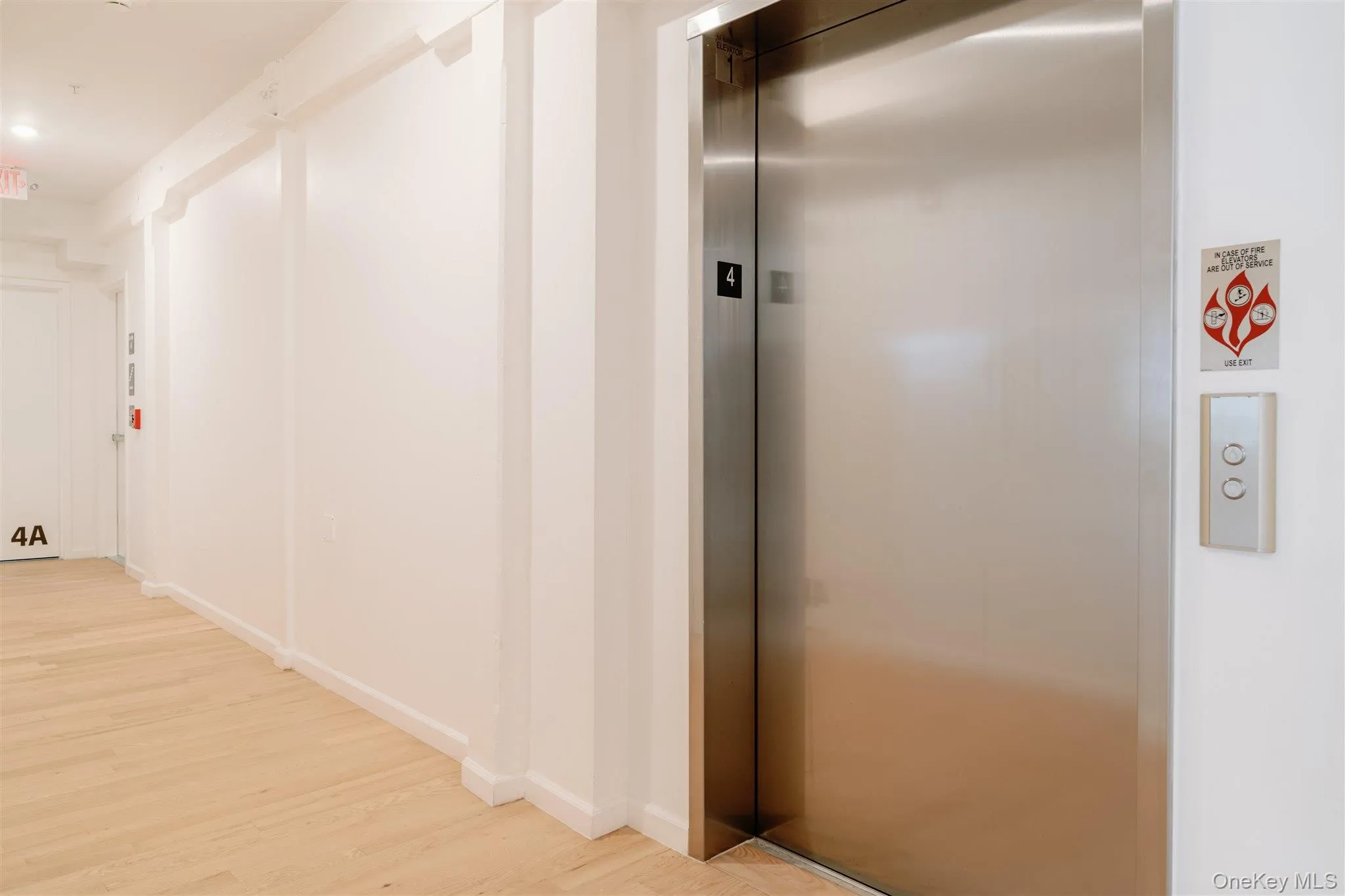 Hall featuring elevator and wood finished floors Hall featuring elevator and wood finished floors