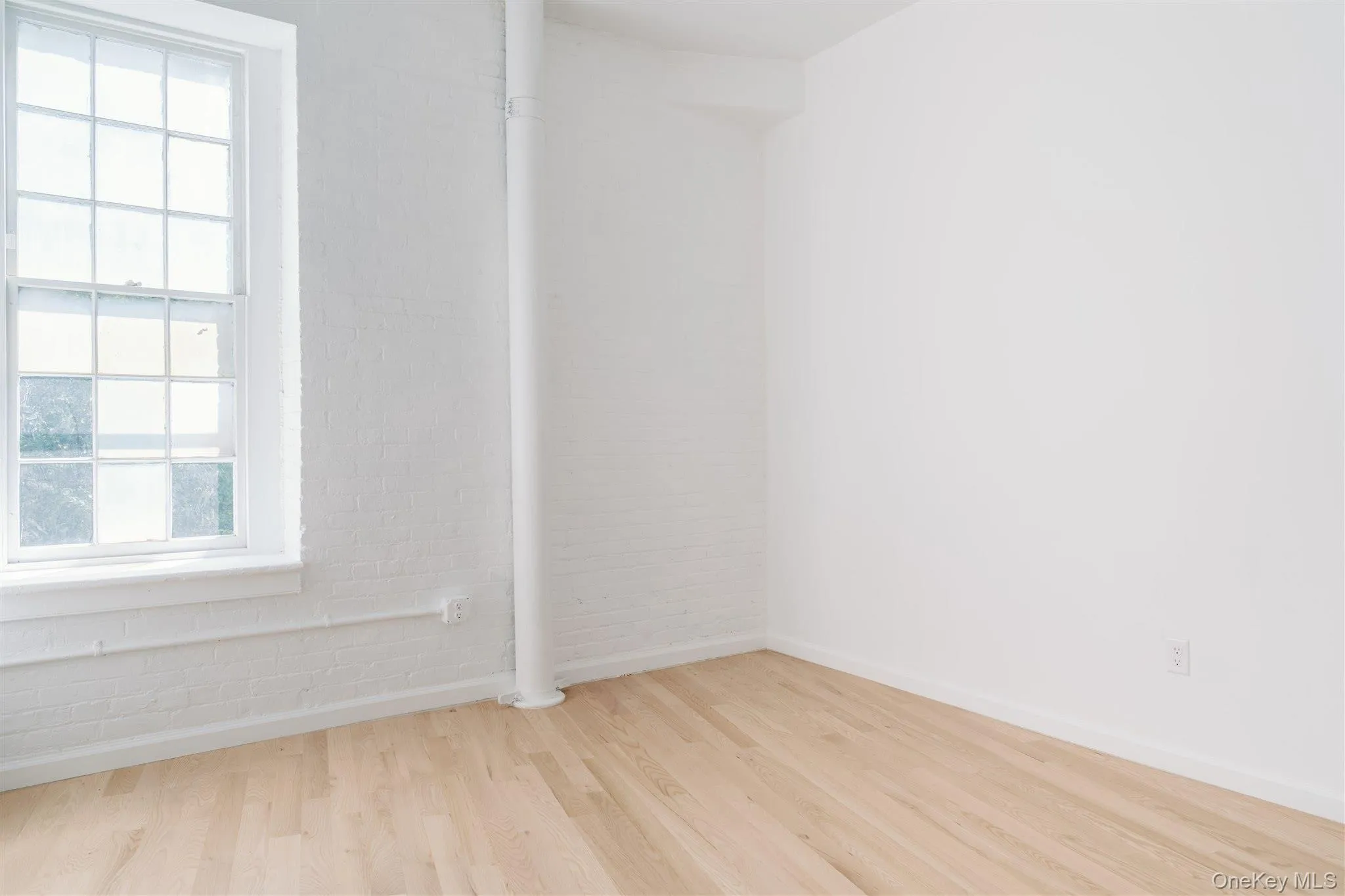 Spare room featuring plenty of natural light and wood finished floors Spare room featuring plenty of natural light and wood finished floors
