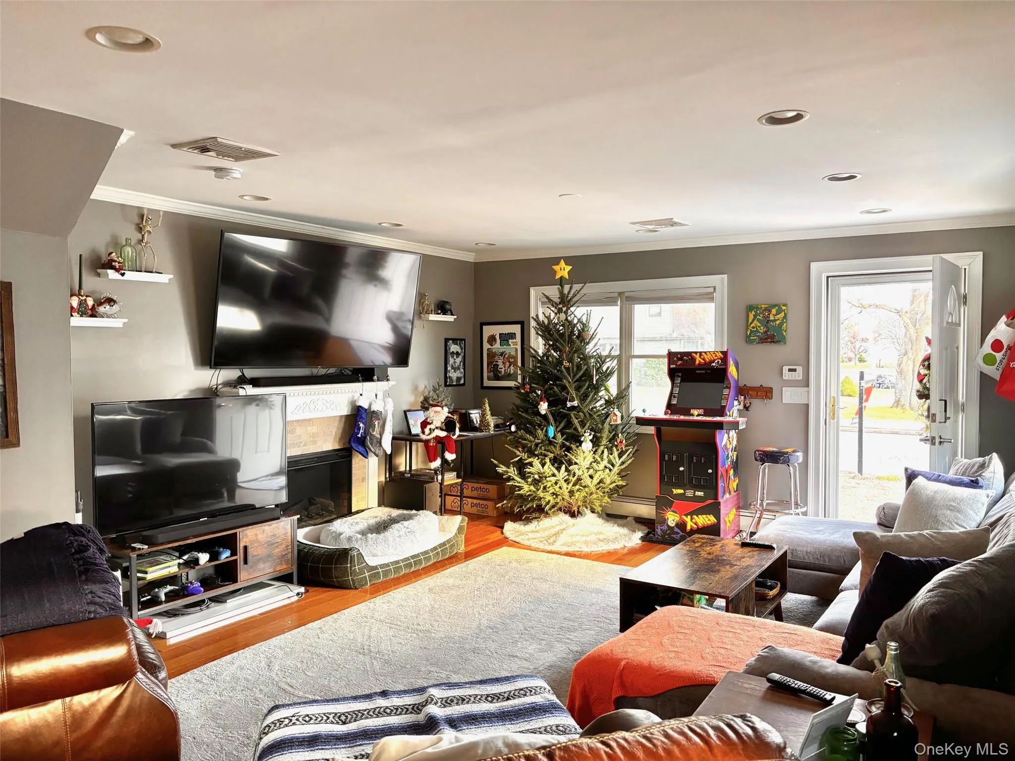 Living room with wood finished floors, crown molding, and recessed lighting Living room with wood finished floors, crown molding, and recessed lighting