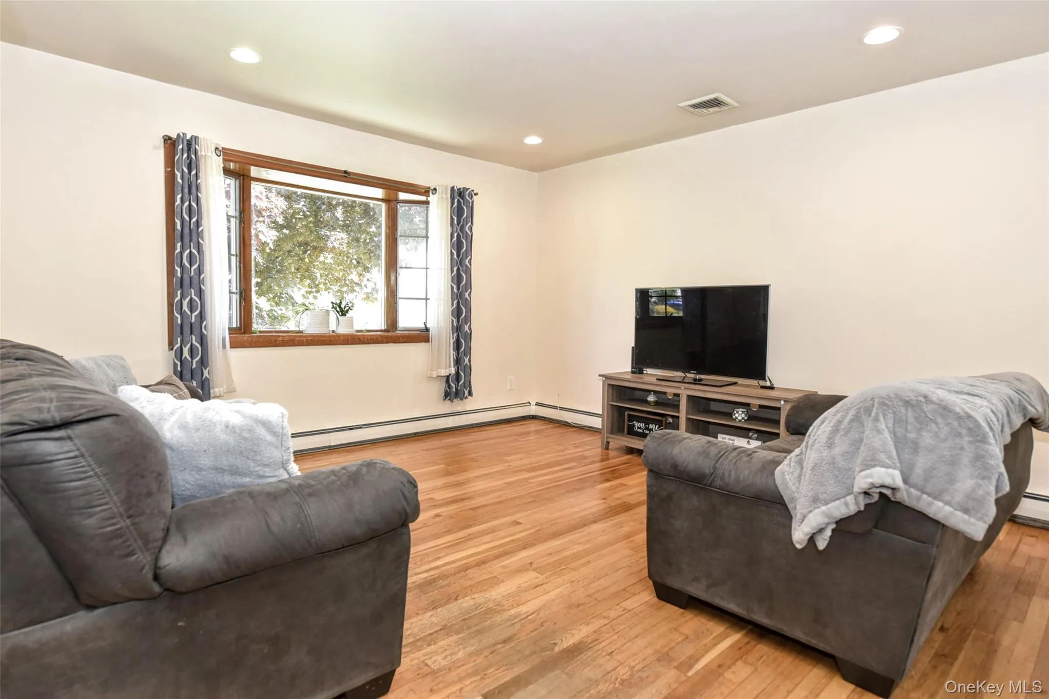 Living room has a bay window with wood trim and recessed lighting Living room has a bay window with wood trim and recessed lighting