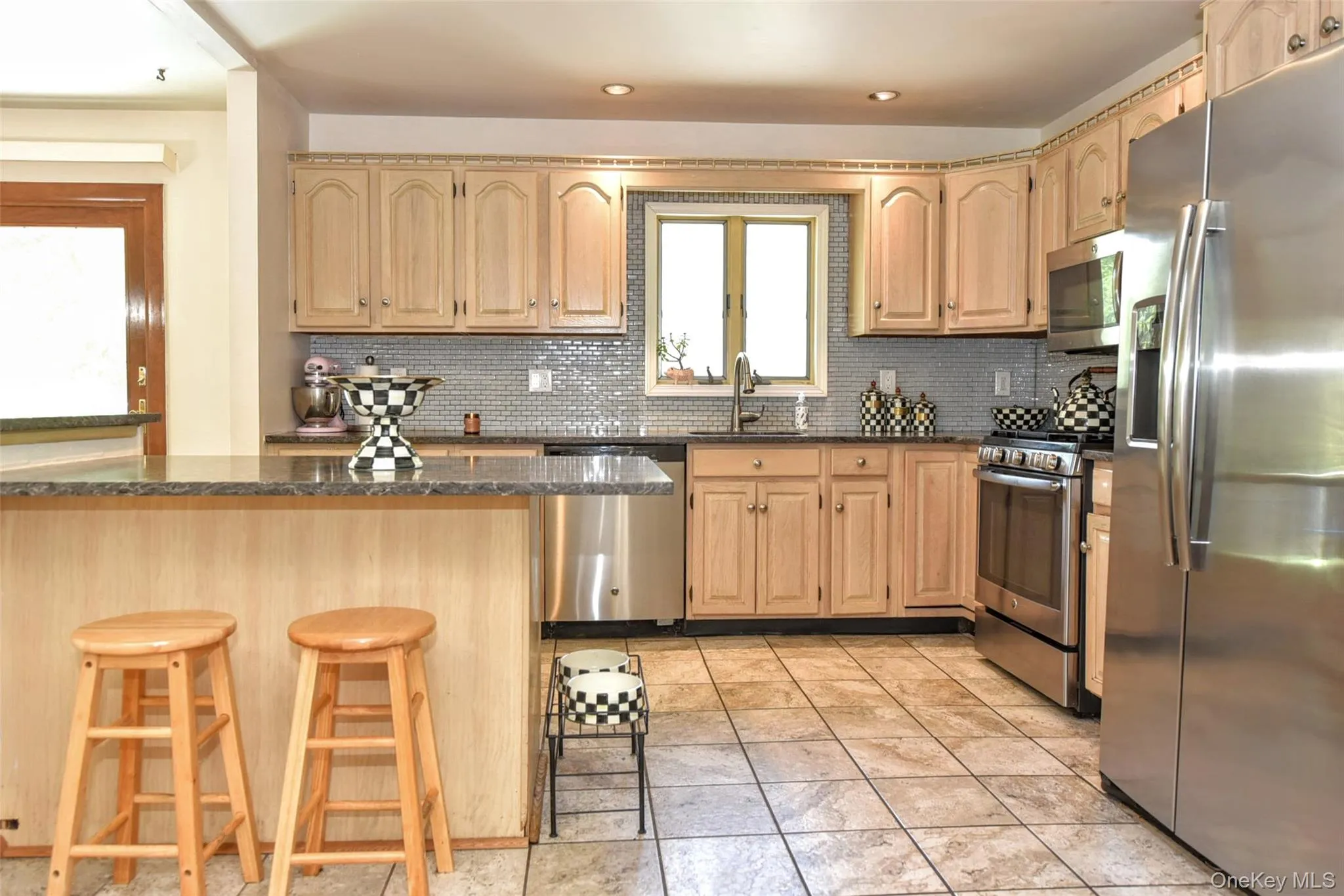 The kitchen offers ample cabinets and a breakfast bar for additional seating The kitchen offers ample cabinets and a breakfast bar for additional seating