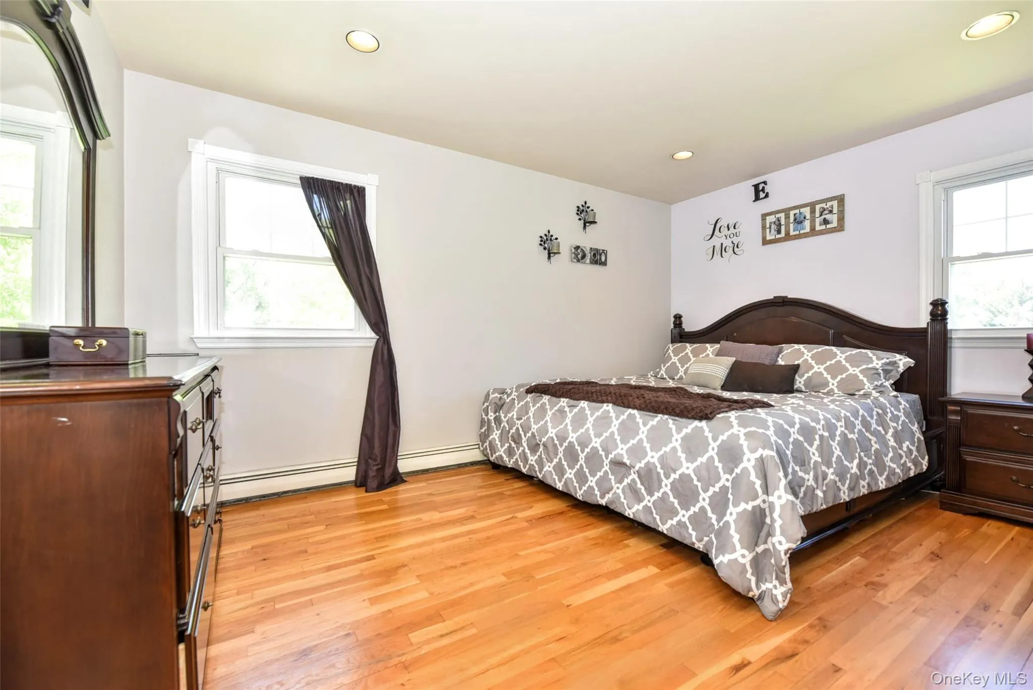 Hardwood flooring with a smooth finish, two windows with white trim, and recessed lighting Hardwood flooring with a smooth finish, two windows with white trim, and recessed lighting