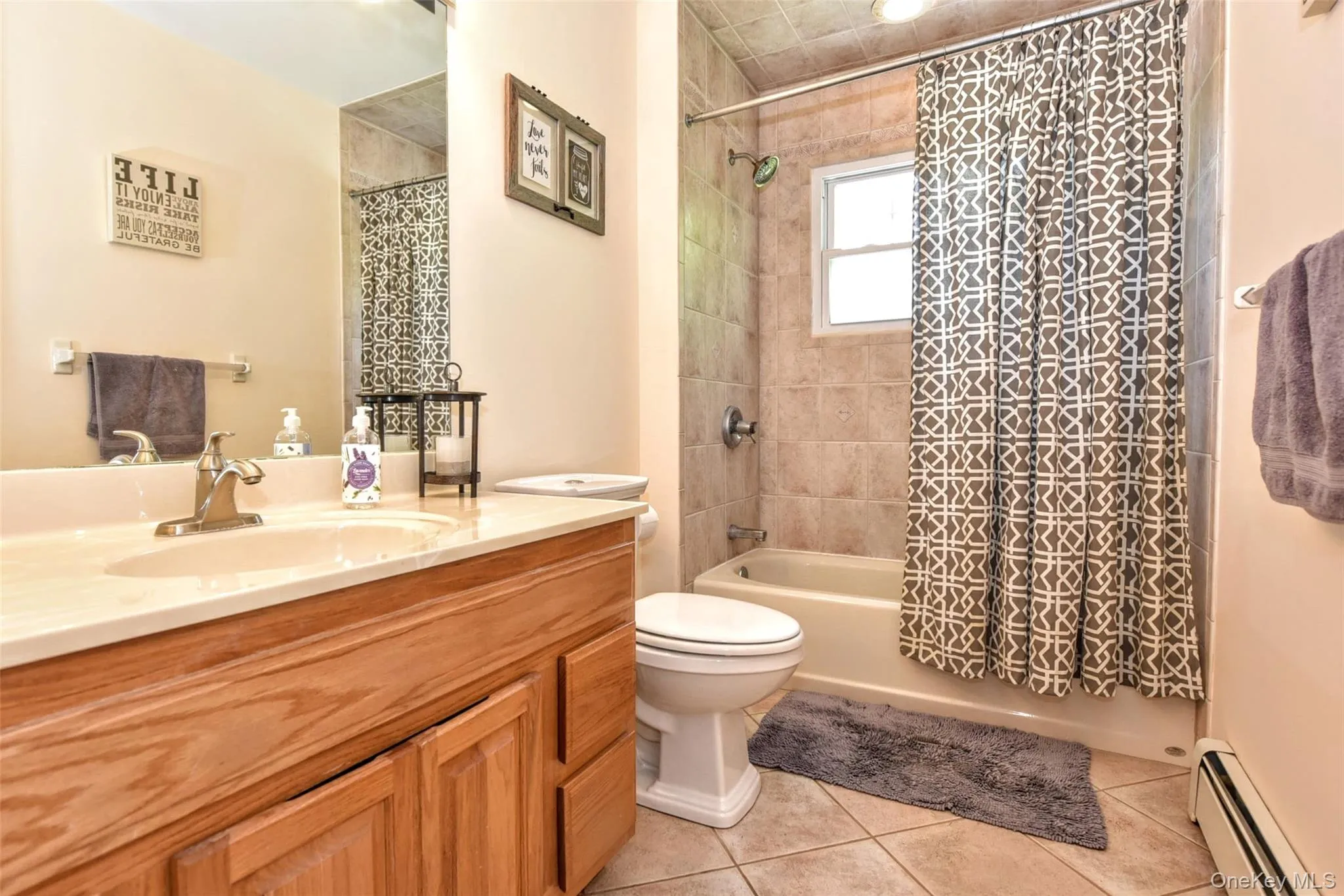 This Bathroom features a wood-finish vanity with an integrated sink and a tile-surround bathtub This Bathroom features a wood-finish vanity with an integrated sink and a tile-surround bathtub