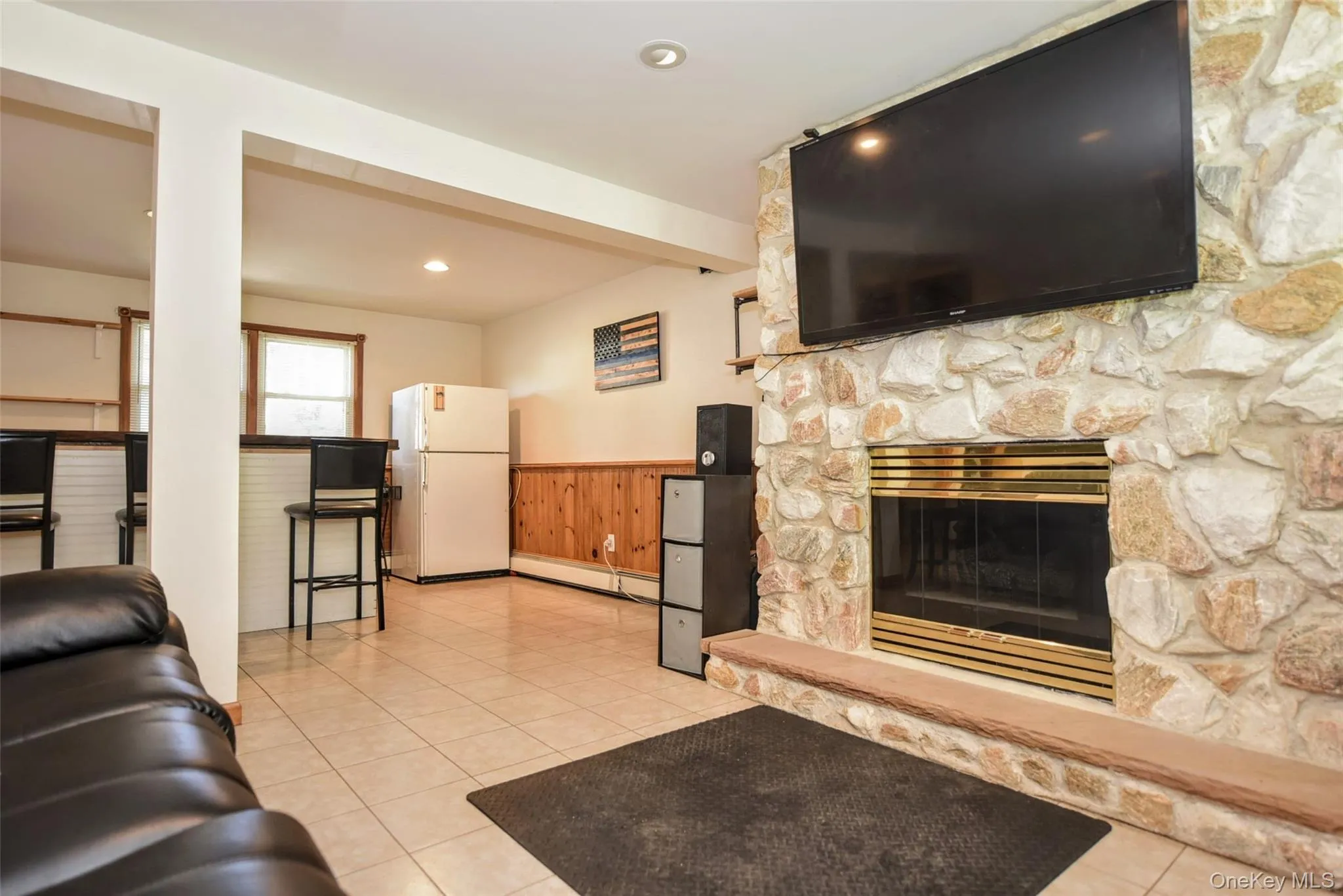 Stone-clad fireplace featuring a brass-trimmed insert and a stone hearth Stone-clad fireplace featuring a brass-trimmed insert and a stone hearth