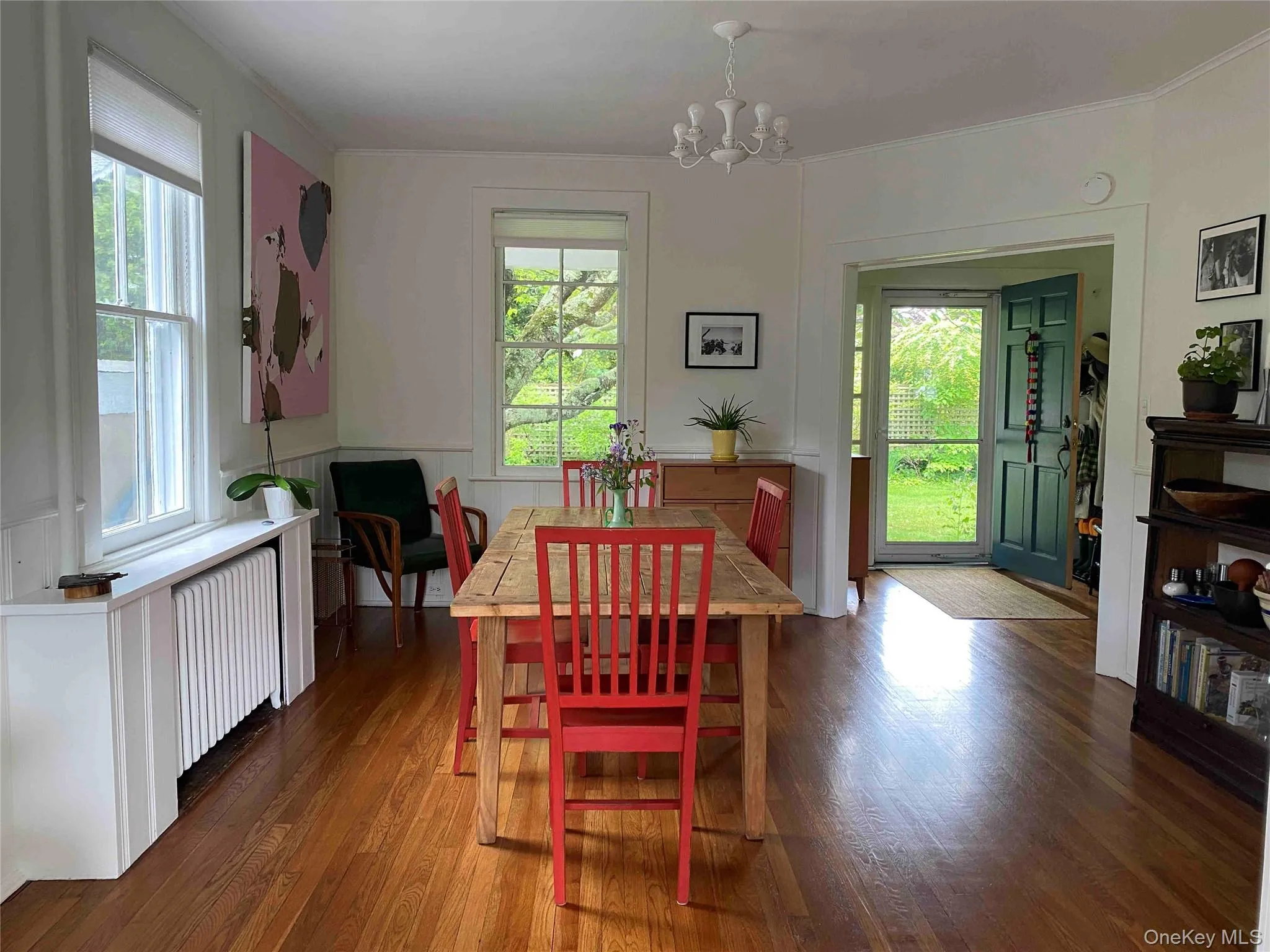 Dining area with healthy amount of natural light, radiator heating unit, hardwood / wood-style floors, and a wainscoted wall Dining area with healthy amount of natural light, radiator heating unit, hardwood / wood-style floors, and a wainscoted wall