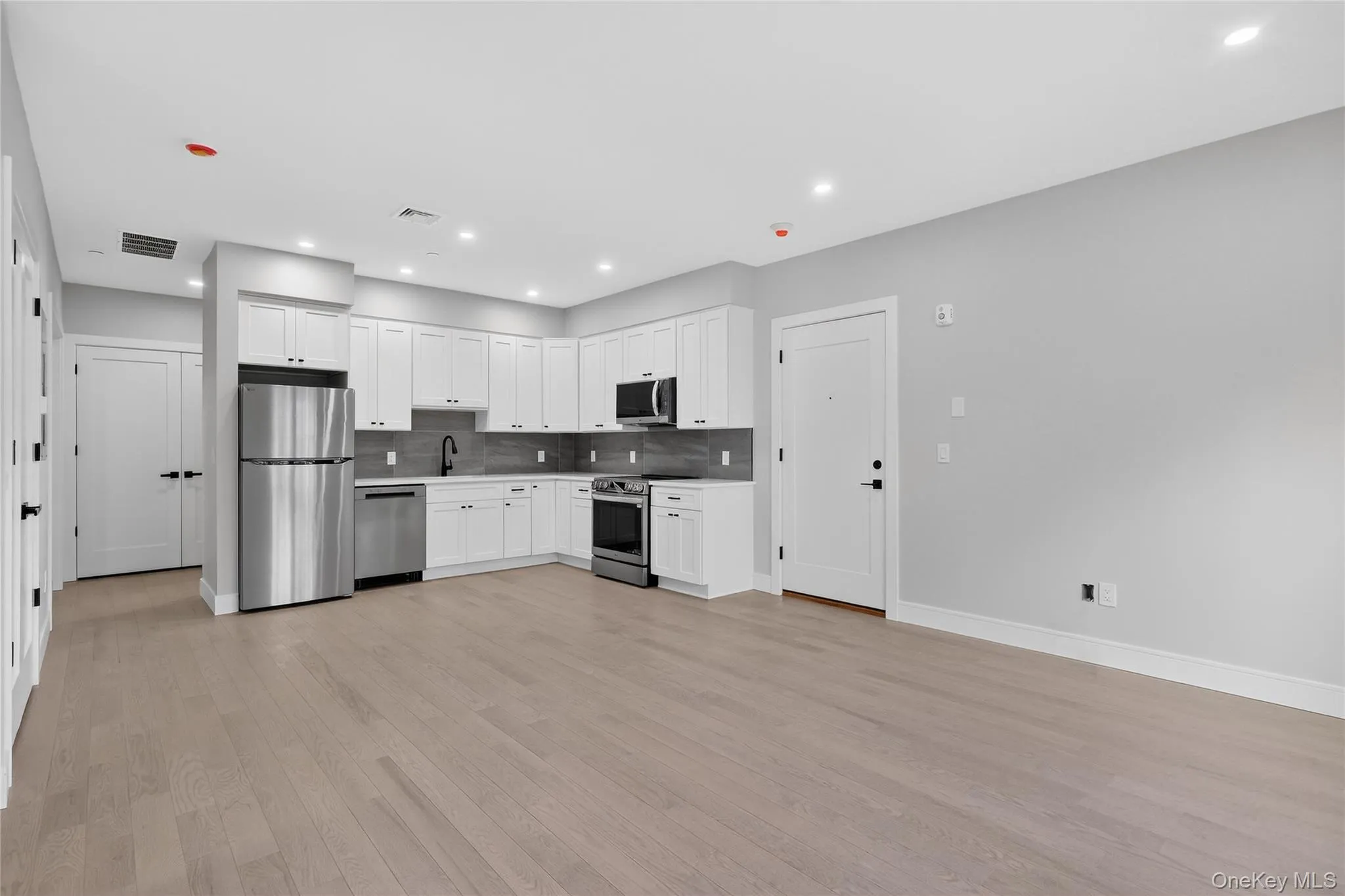 Kitchen featuring white cabinetry, appliances with stainless steel finishes, light countertops, tasteful backsplash, and recessed lighting Kitchen featuring white cabinetry, appliances with stainless steel finishes, light countertops, tasteful backsplash, and recessed lighting