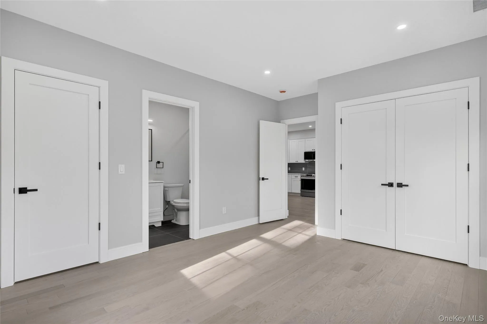 Unfurnished bedroom featuring light wood-style flooring, a closet, recessed lighting, and ensuite bath Unfurnished bedroom featuring light wood-style flooring, a closet, recessed lighting, and ensuite bath