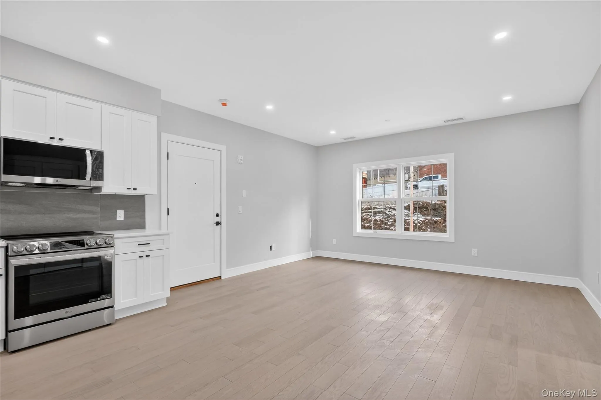 Kitchen with stainless steel appliances, white cabinets, light wood-style flooring, and recessed lighting Kitchen with stainless steel appliances, white cabinets, light wood-style flooring, and recessed lighting
