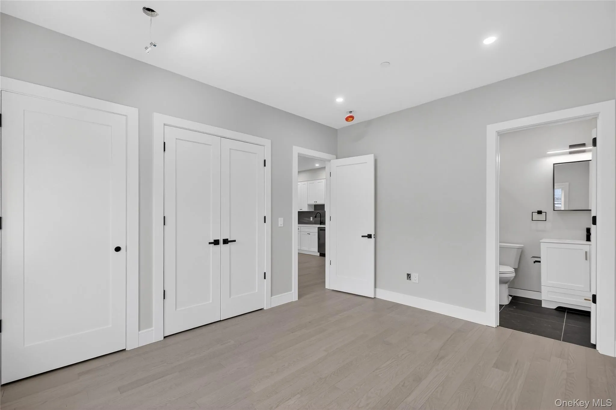 Unfurnished bedroom with light wood-style flooring, a closet, recessed lighting, and connected bathroom Unfurnished bedroom with light wood-style flooring, a closet, recessed lighting, and connected bathroom