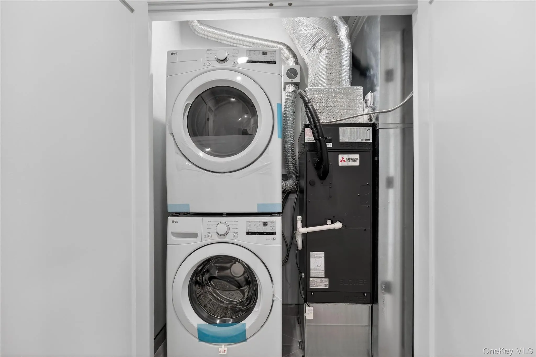 Laundry room featuring estacked washer and dryer and heating unit Laundry room featuring estacked washer and dryer and heating unit