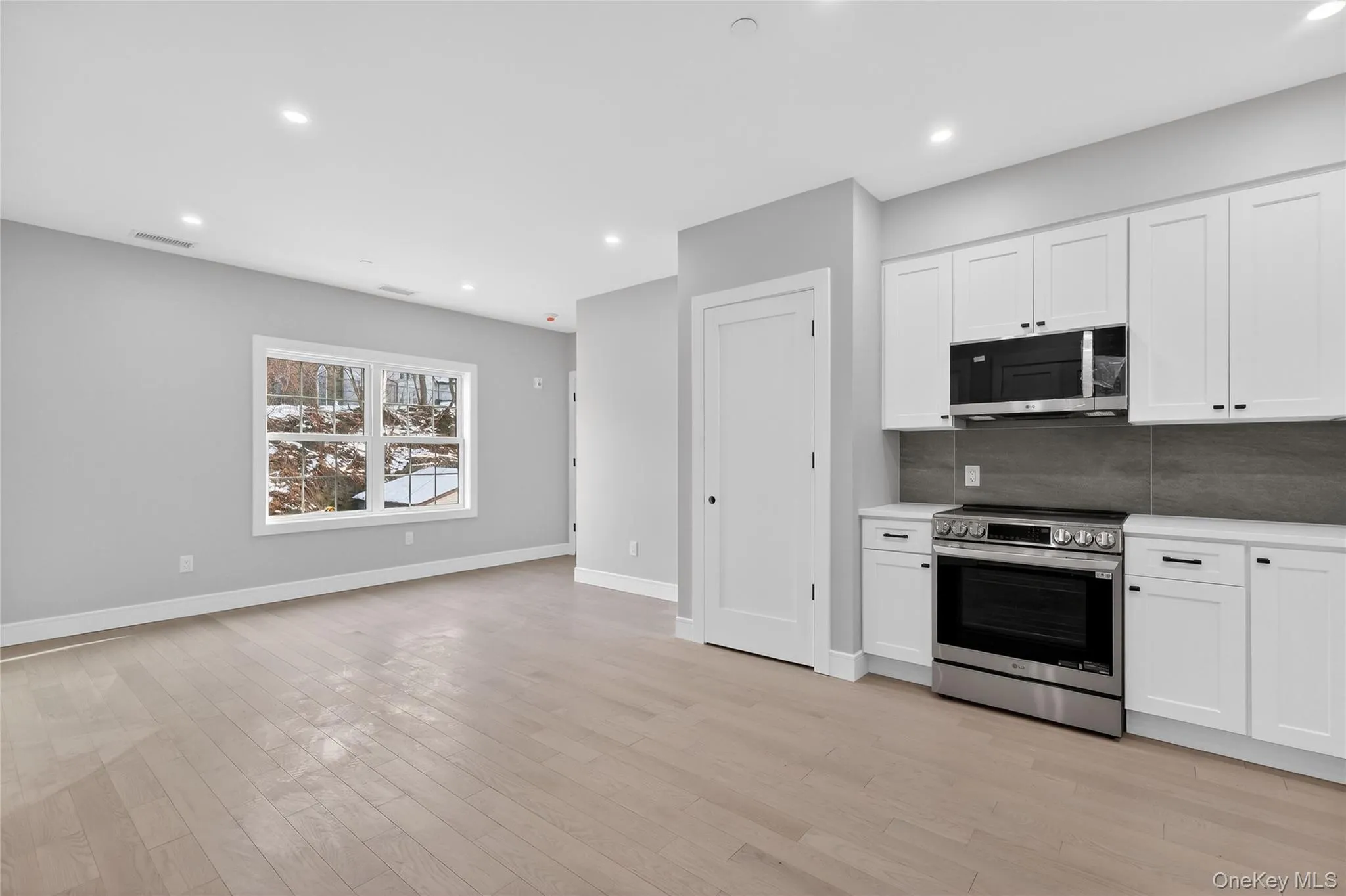 Kitchen with stainless steel appliances, white cabinetry, recessed lighting, decorative backsplash, and light wood-style flooring Kitchen with stainless steel appliances, white cabinetry, recessed lighting, decorative backsplash, and light wood-style flooring