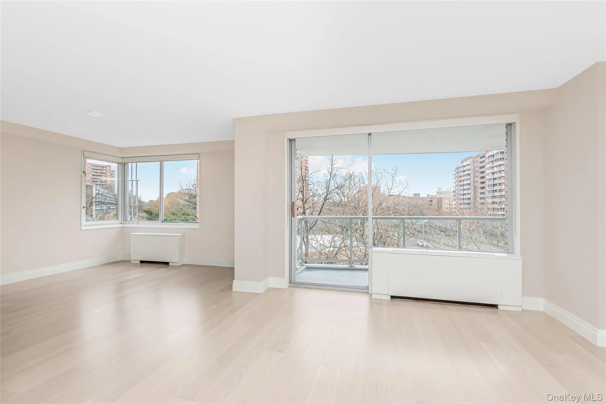 Unfurnished room featuring radiator heating unit and light wood-type flooring Unfurnished room featuring radiator heating unit and light wood-type flooring