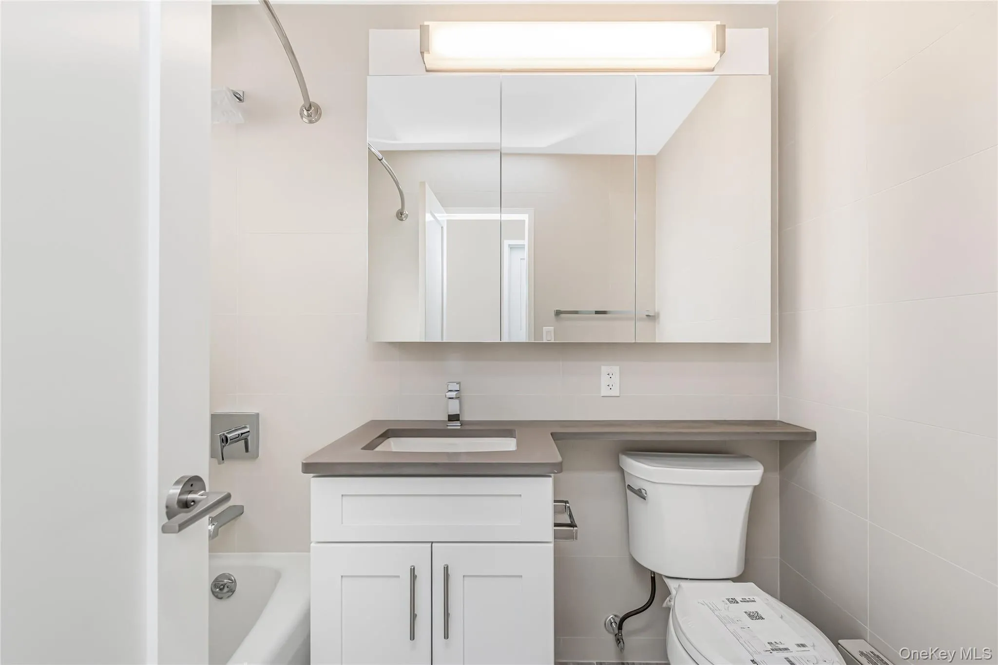 Full bath with vanity, washtub / shower combination, and tile walls Full bath with vanity, washtub / shower combination, and tile walls