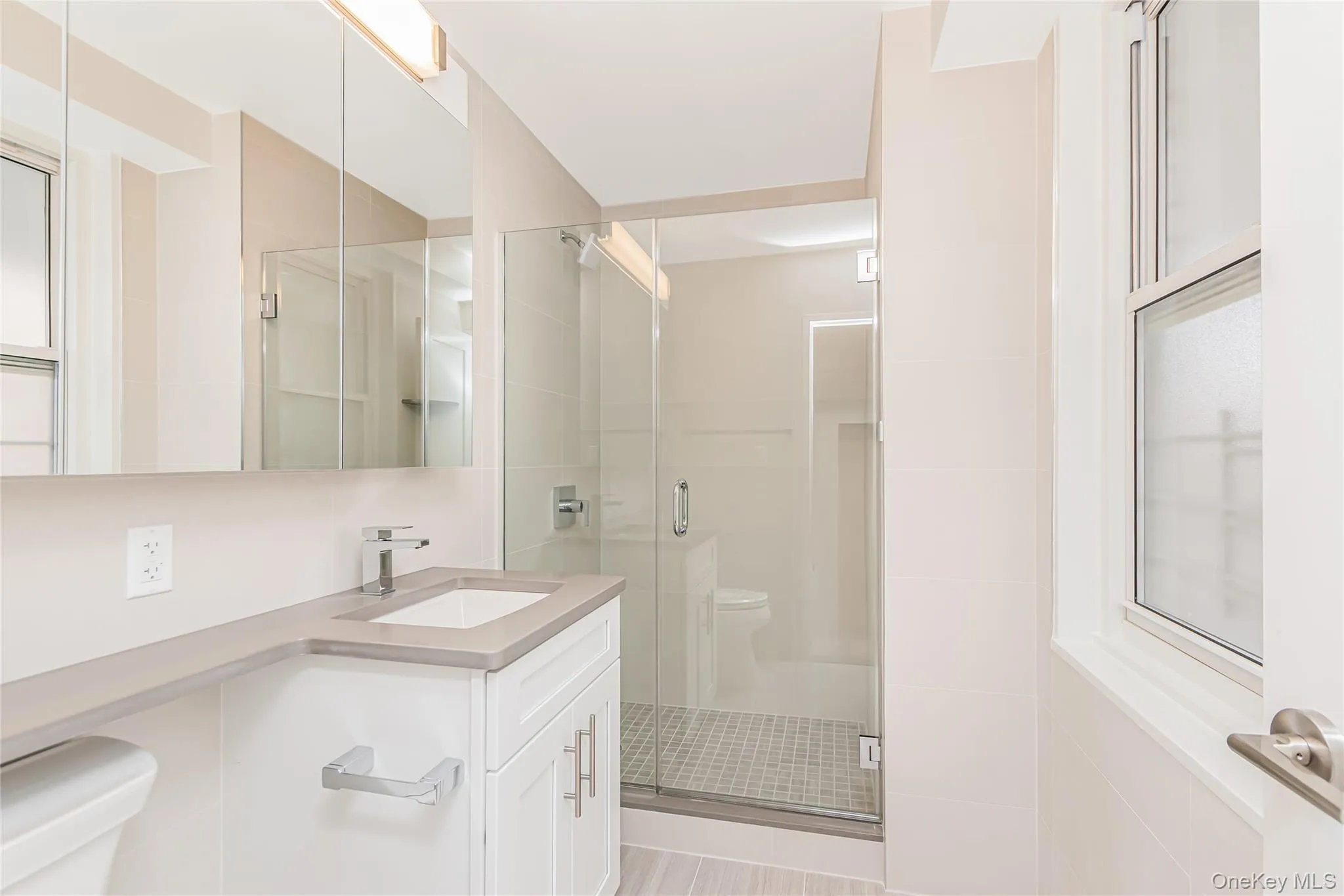 Full bathroom featuring a stall shower, vanity, and tile walls Full bathroom featuring a stall shower, vanity, and tile walls