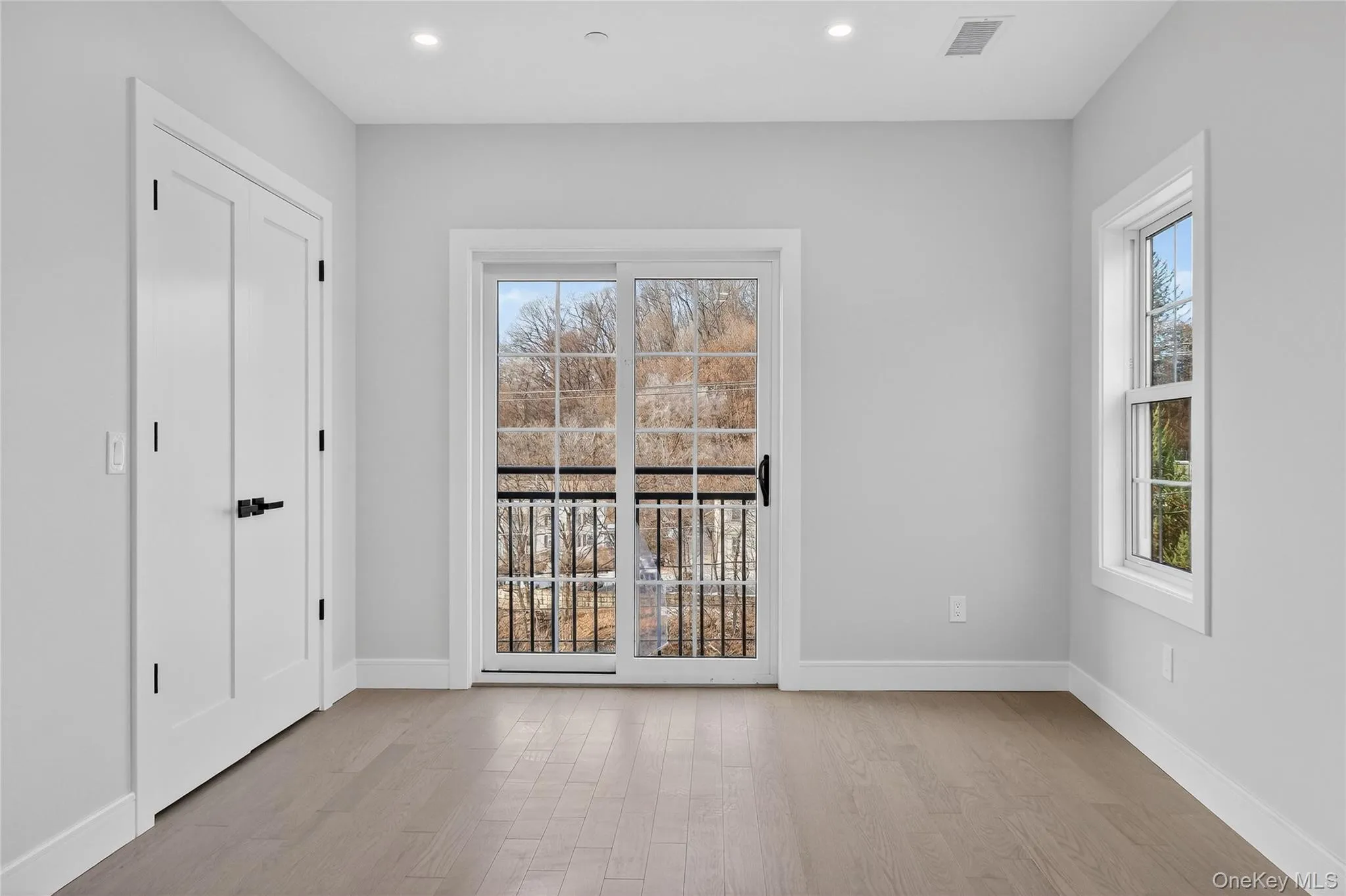 Unfurnished bedroom with light wood finished floors, access to exterior, and recessed lighting Unfurnished bedroom with light wood finished floors, access to exterior, and recessed lighting